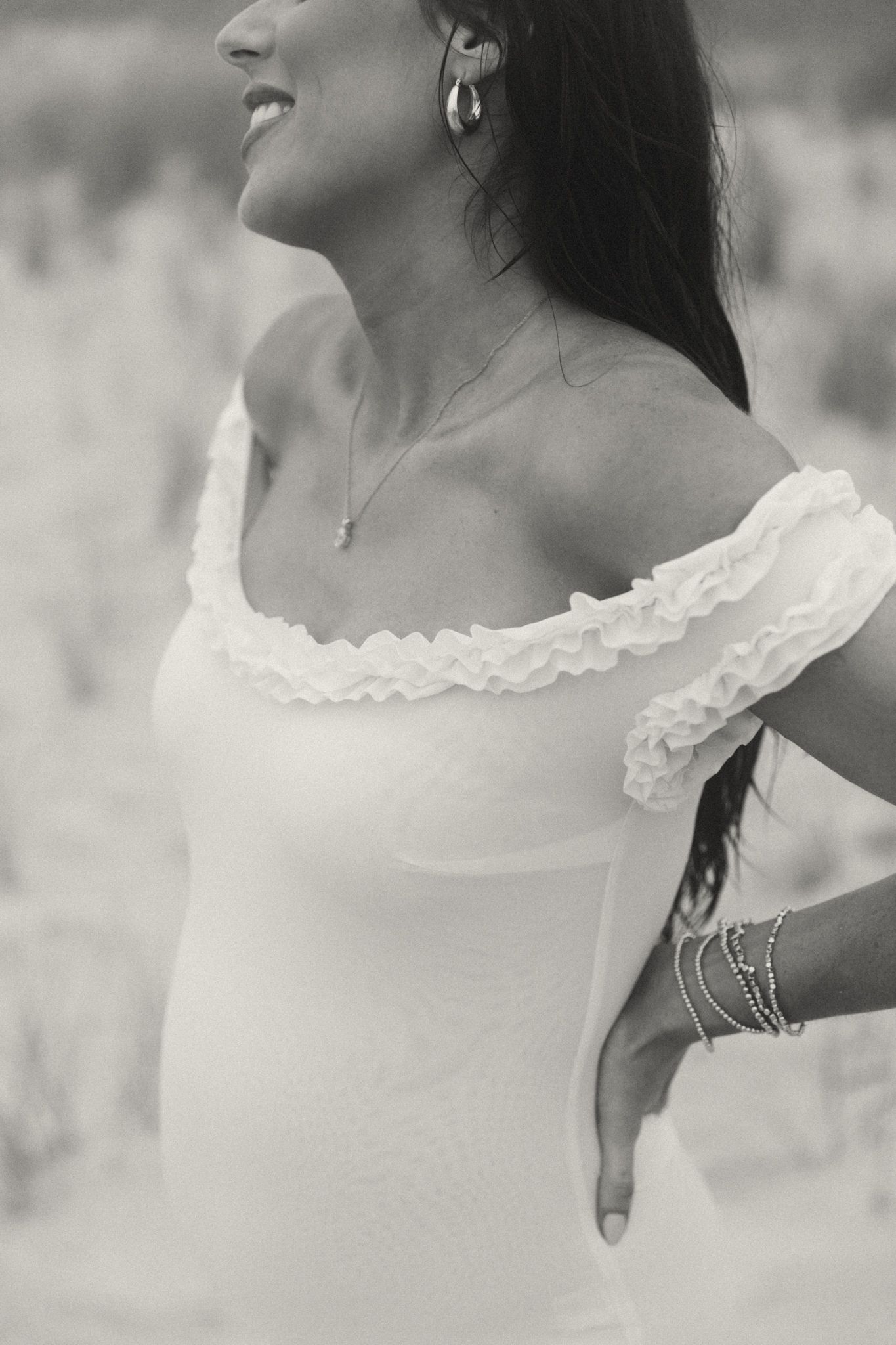 Close-up black and white portrait showing elegant jewelry and lace collar details.