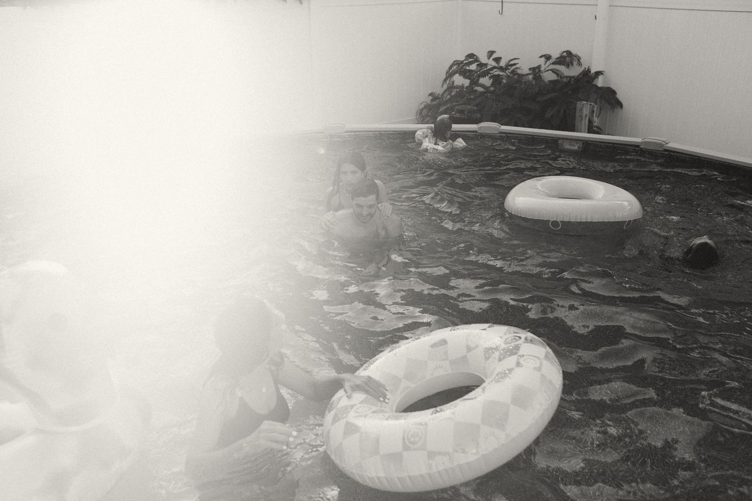 Vintage black and white photo of pool floats in dark water.