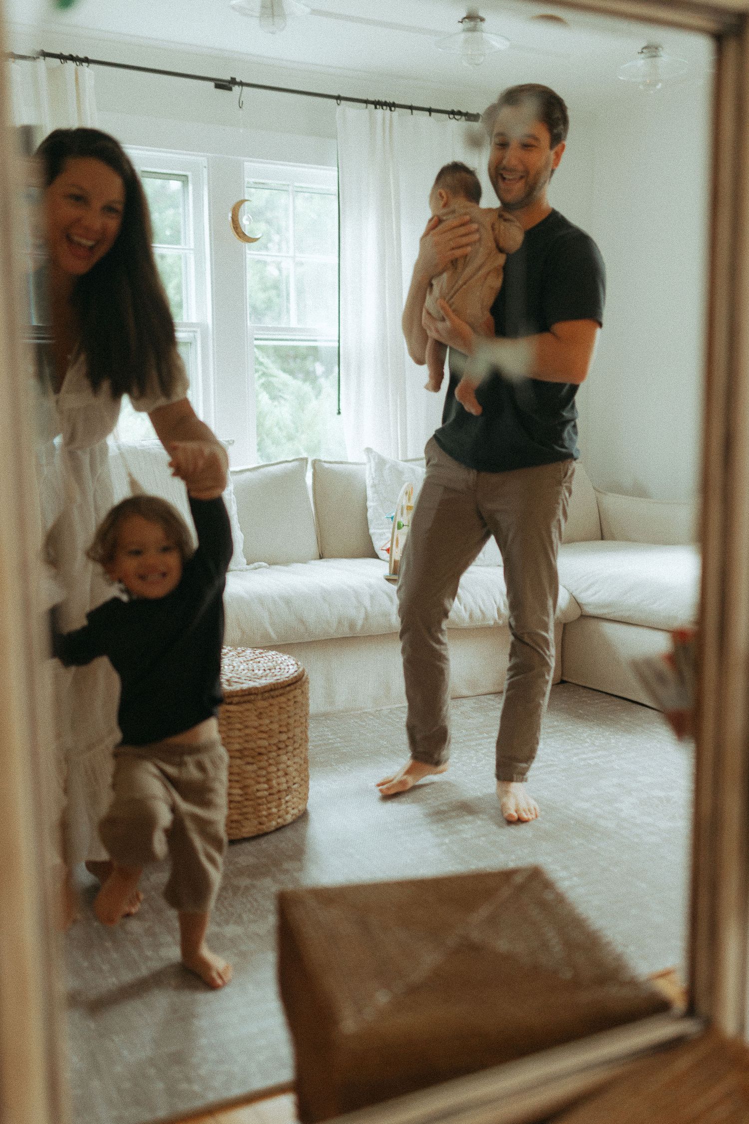 Playful scene reflected in a mirror showing casual interactions in a bright room.