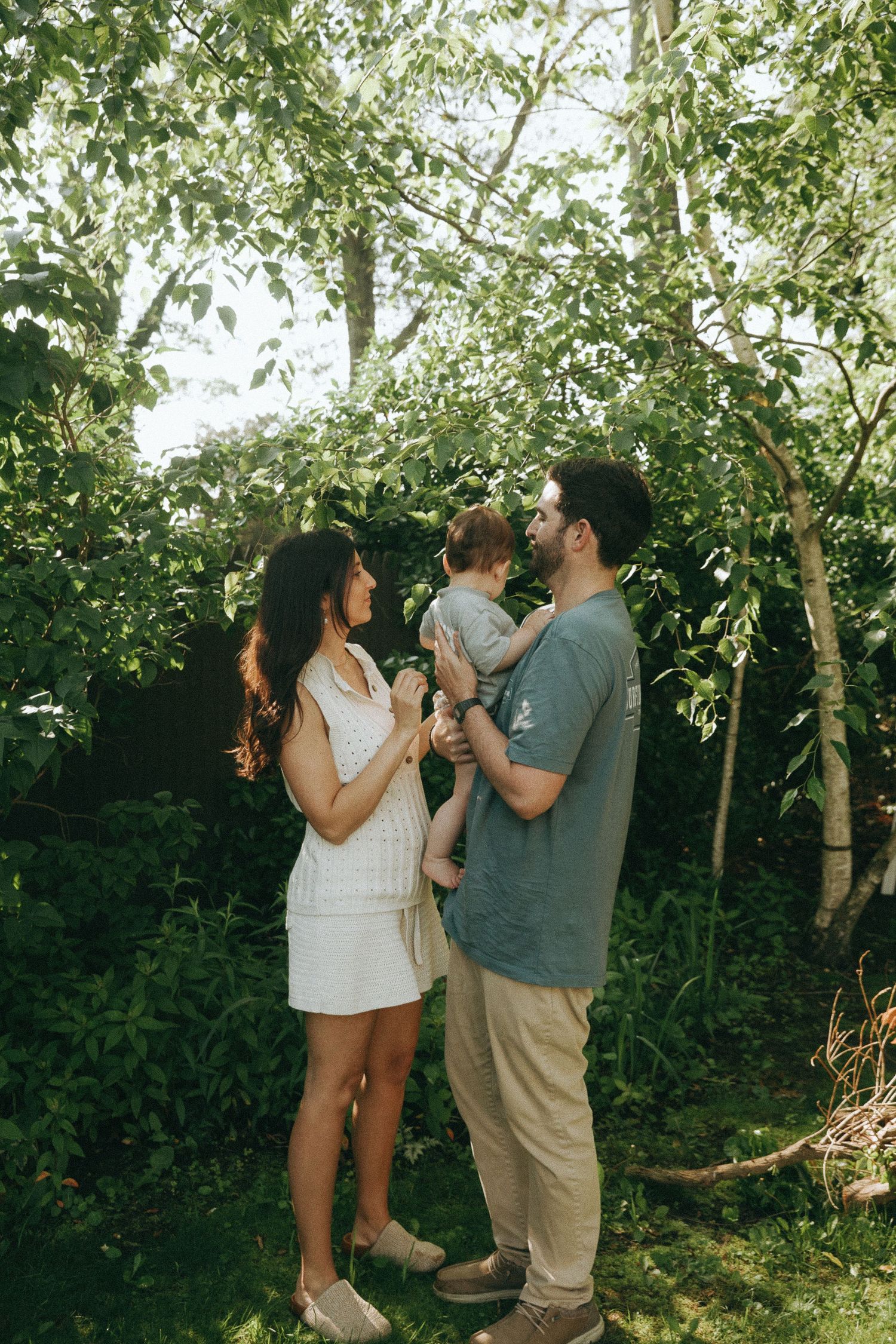 People sharing intimate moments in a sunlit garden setting.