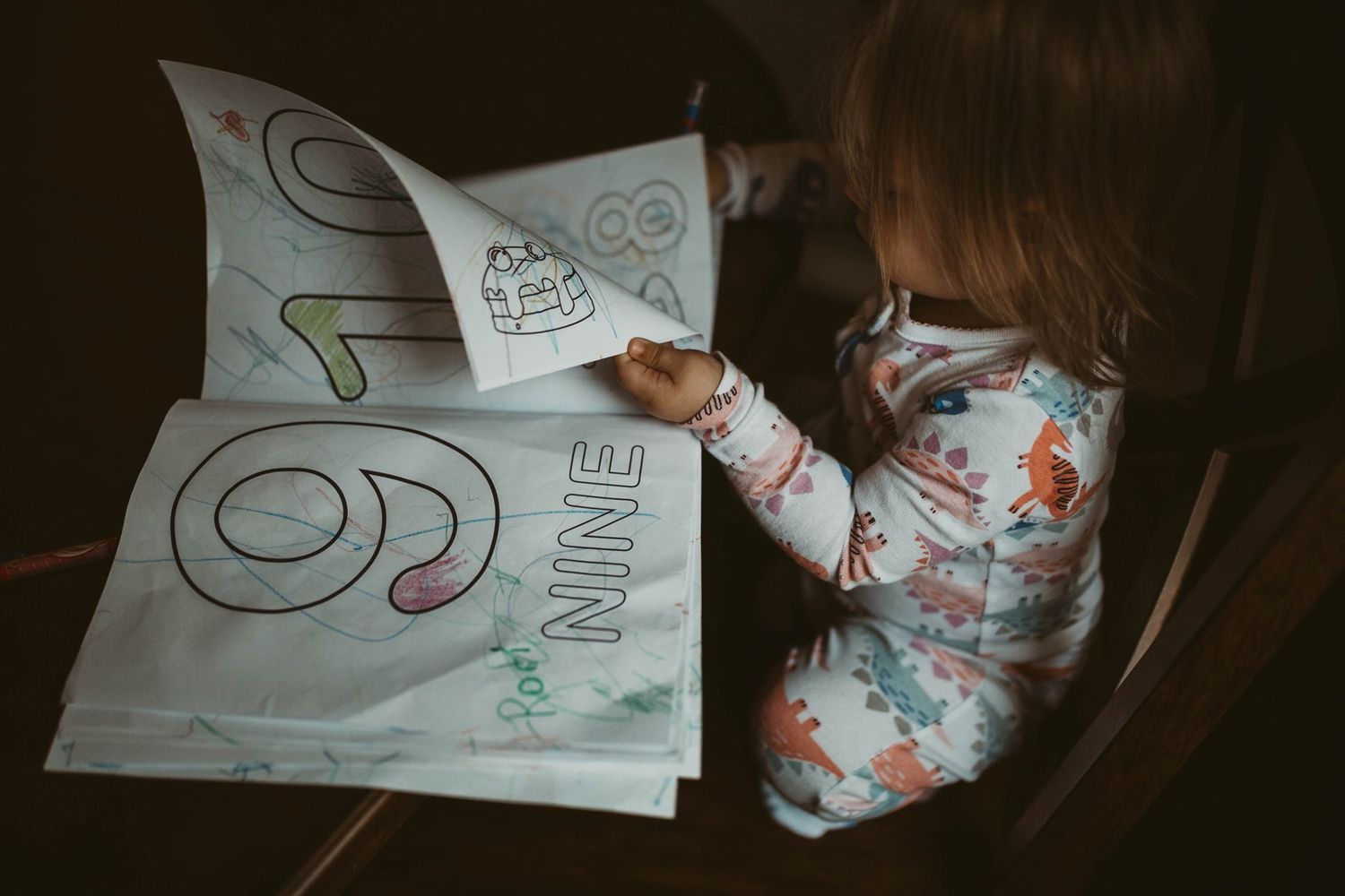 Drawing materials and artwork laid out on a dark surface.
