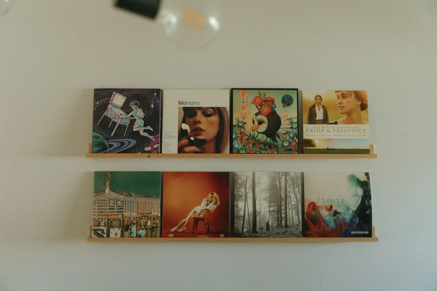 Art prints and posters displayed on floating wall shelves create a modern gallery wall display.