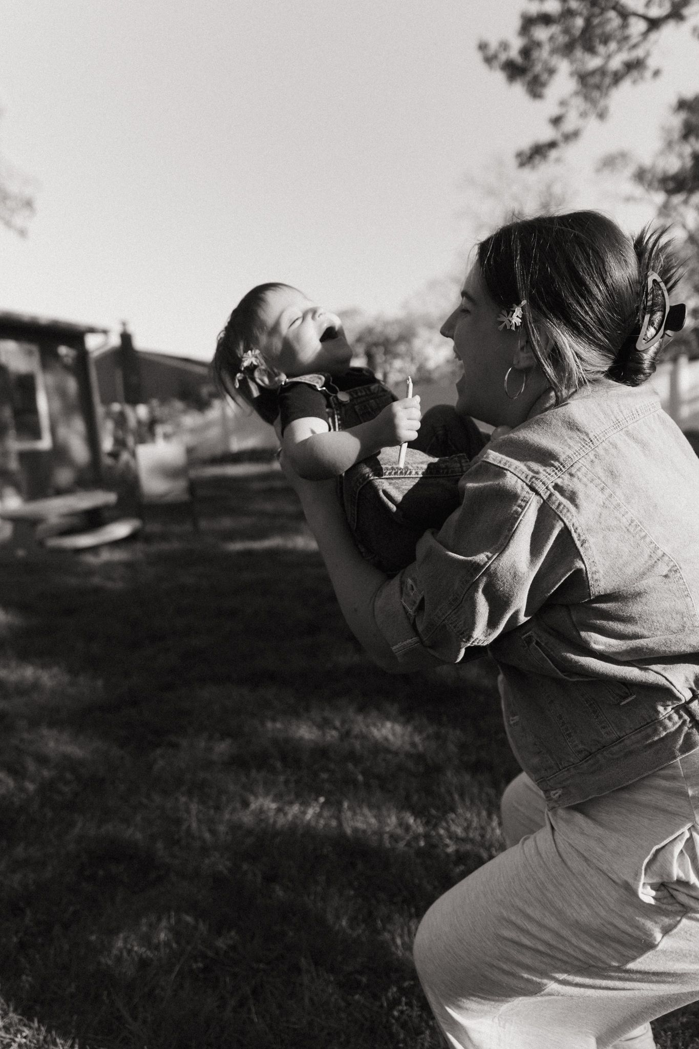 Black and white photograph of outdoor playtime in late afternoon sunlight.