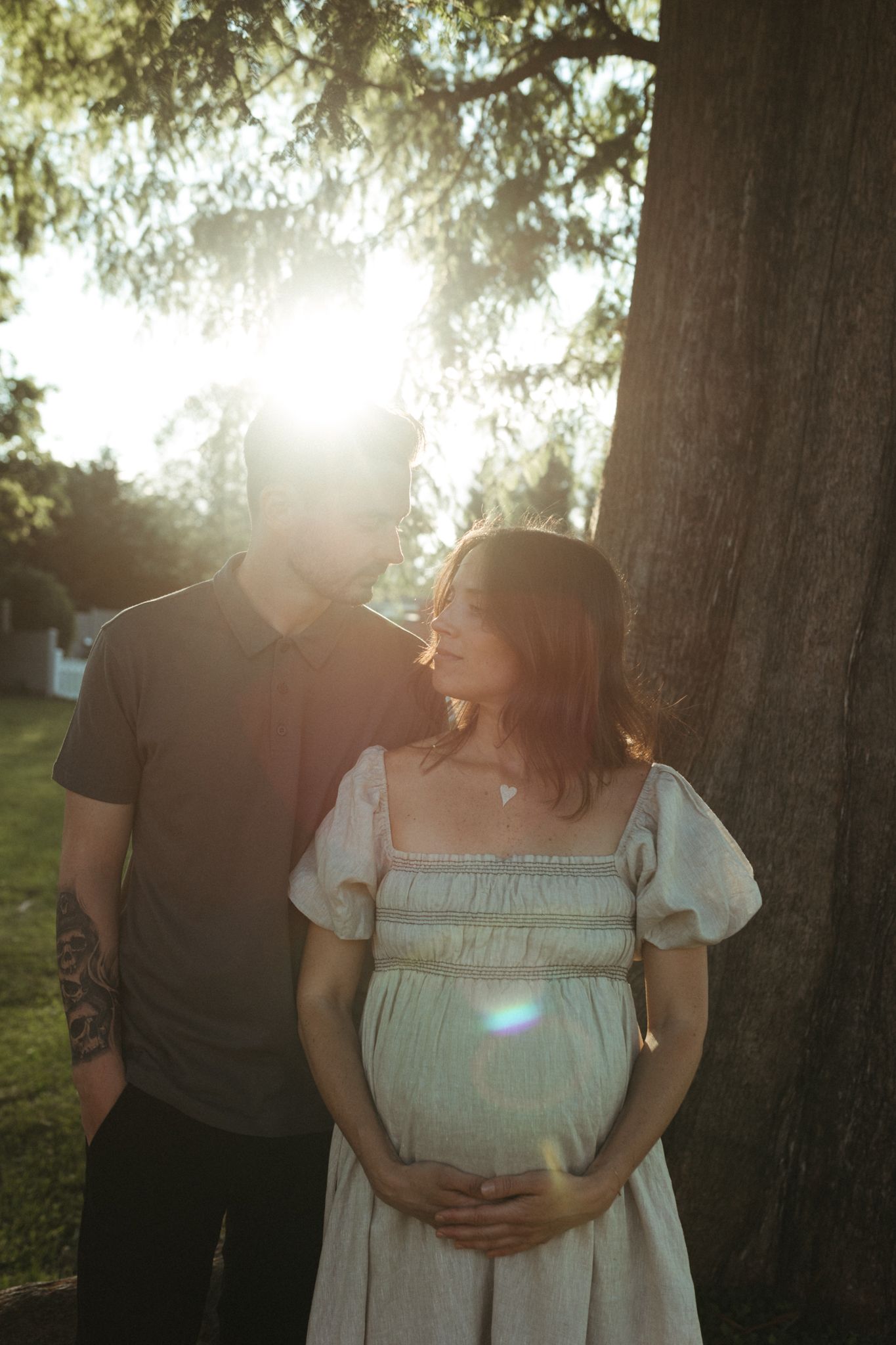 A romantic sunset photoshoot in a park with golden sunlight filtering through trees.