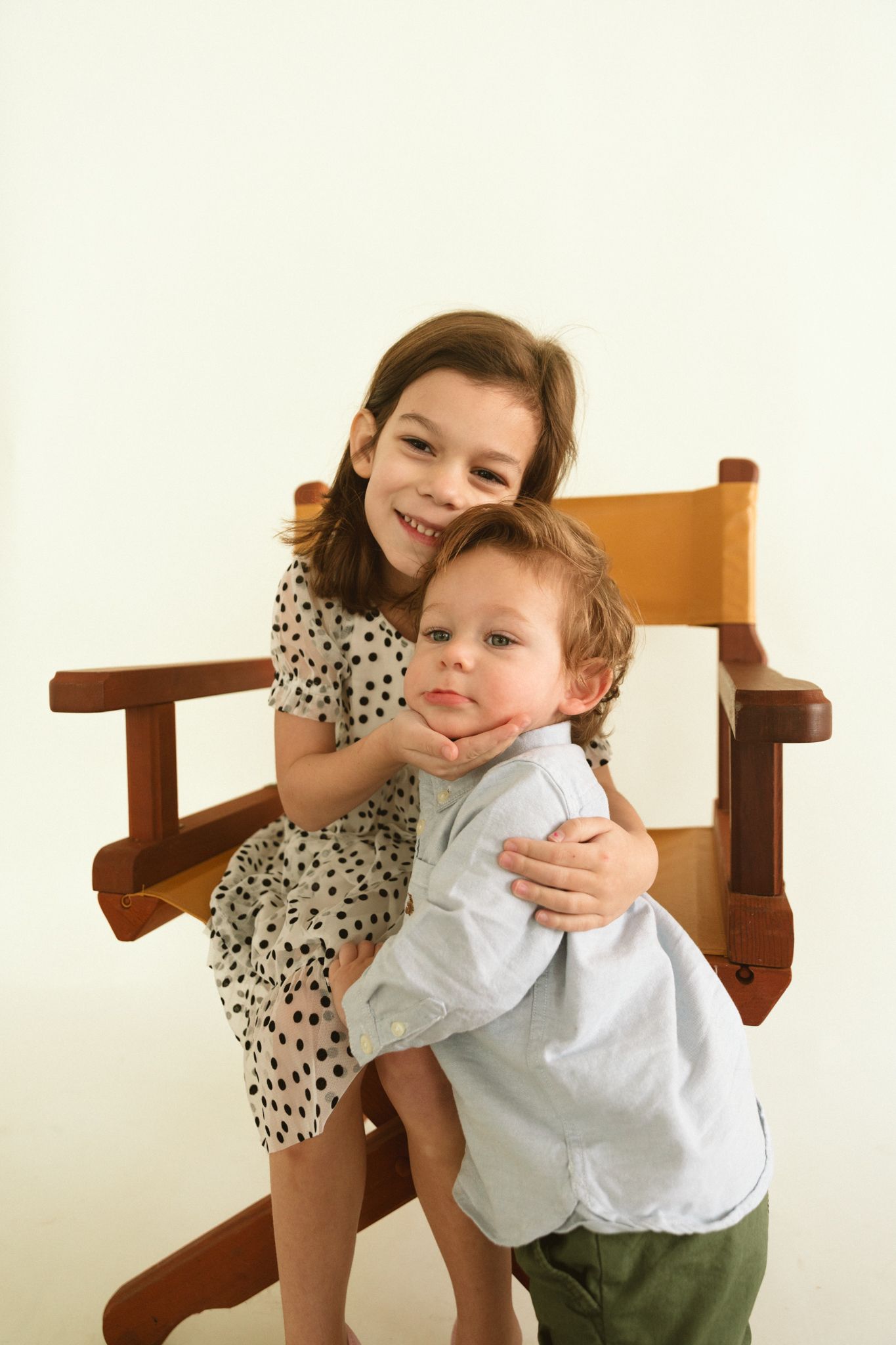 Candid moments of play and laughter on a wooden chair against a white background.
