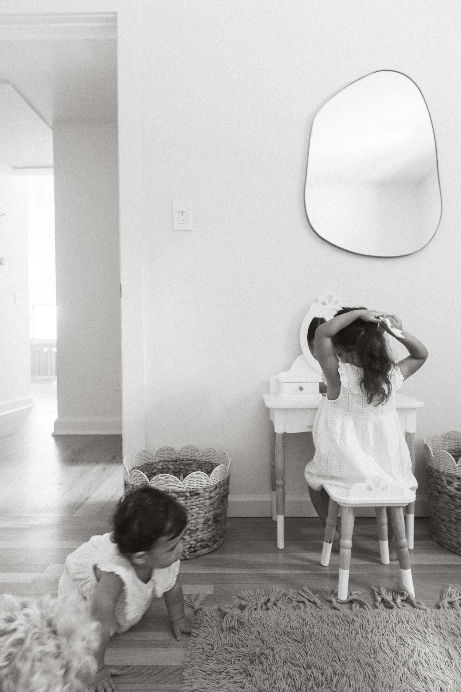 A minimalist white interior with a mirror and scattered toys on a plush carpet.