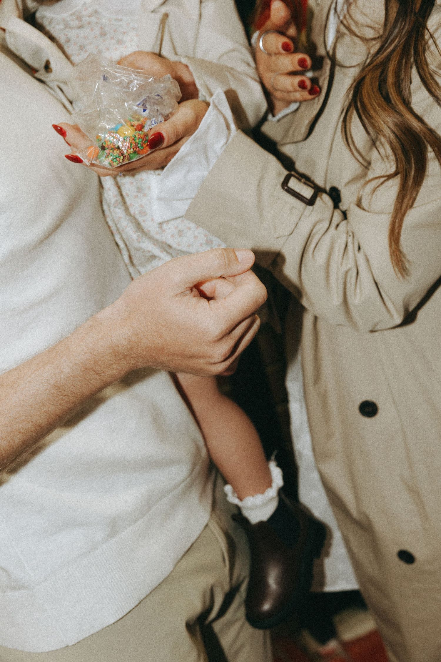 Close-up view of hands holding delicate items against a light-colored background.