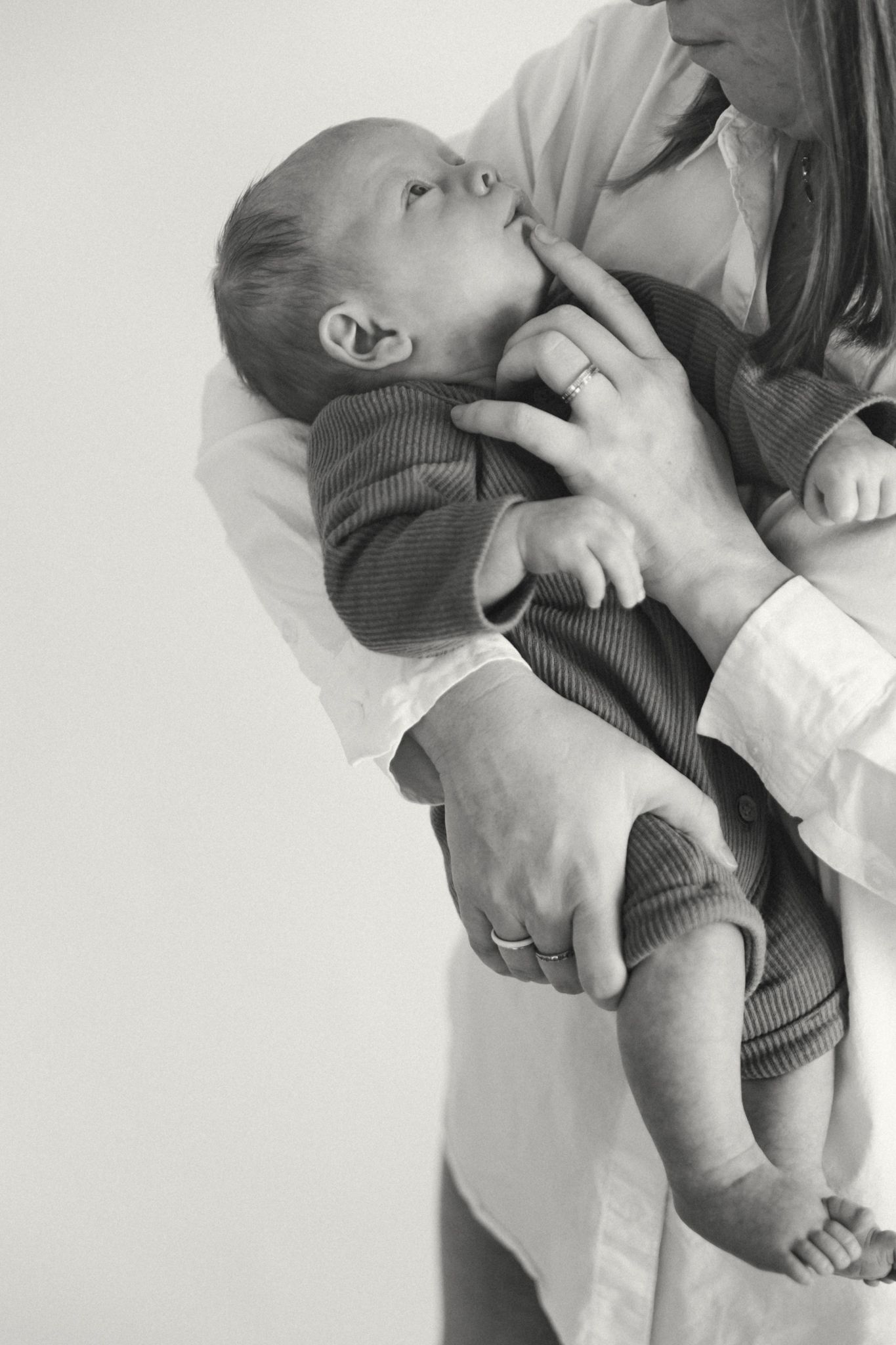 Close-up sequence showing gentle parent-child interaction in black and white tones.