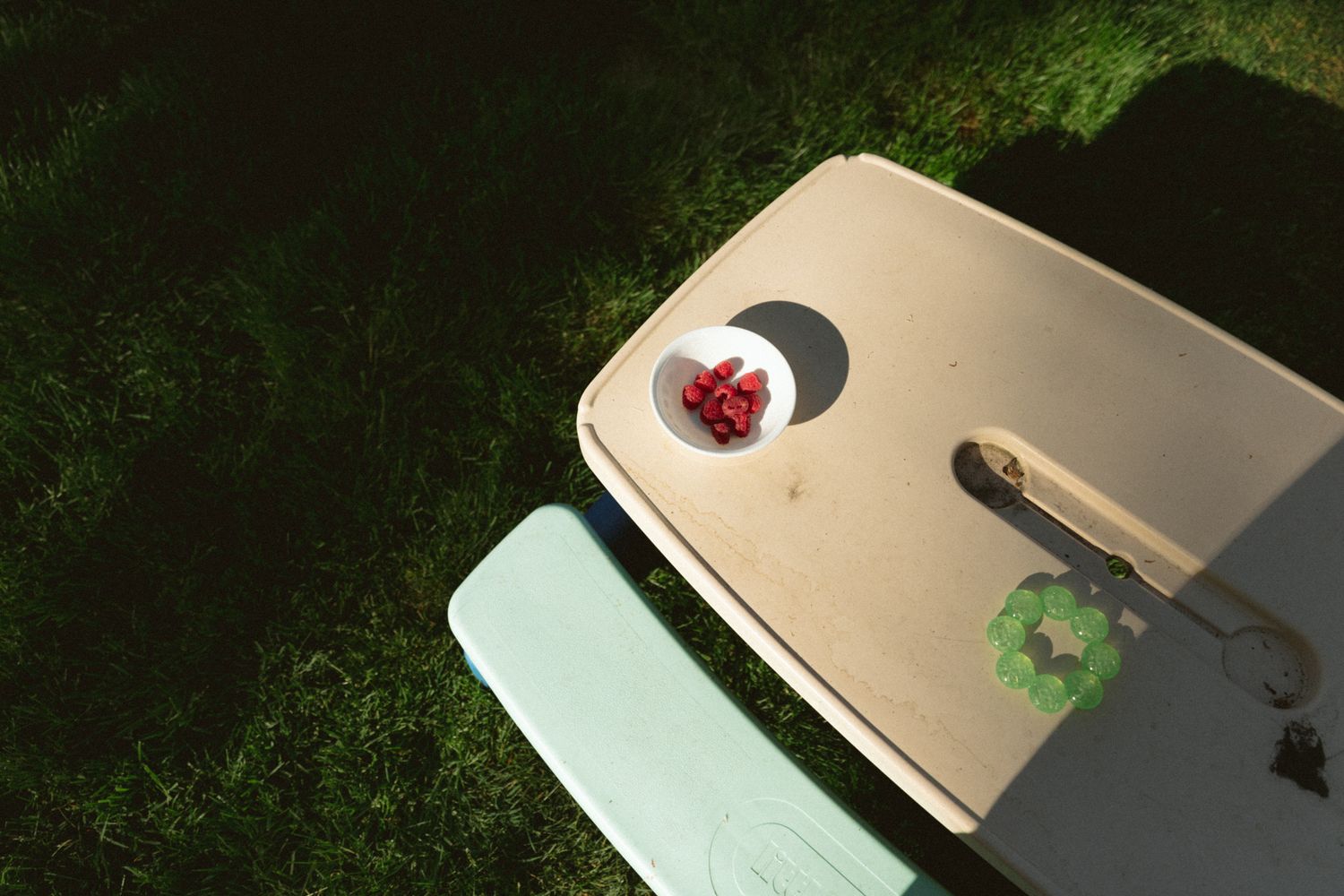 A minimalist outdoor scene with a strawberry dessert on a beige table surface.