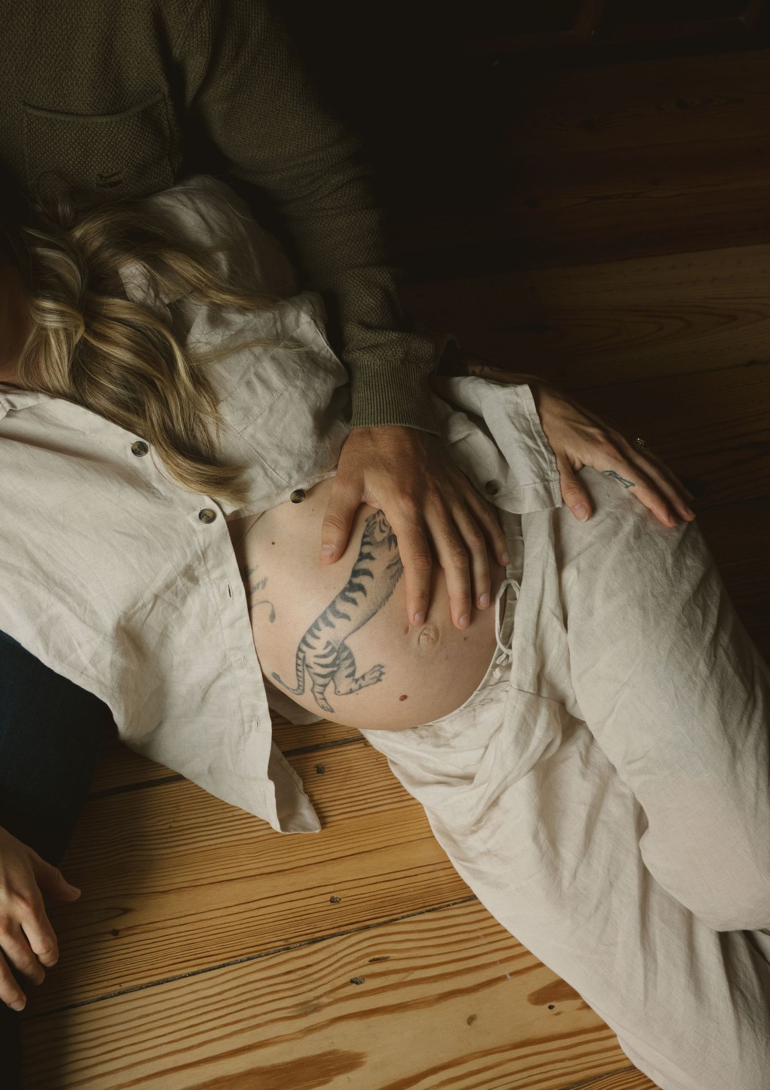 Artistic overhead shots showing tattoo details on skin against wooden surfaces.