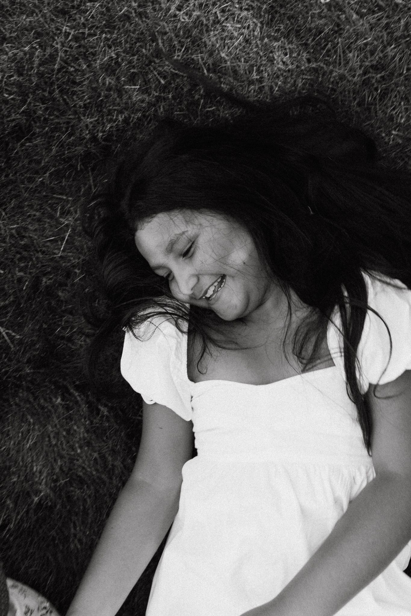 Black and white portrait of someone lying down with long dark hair.