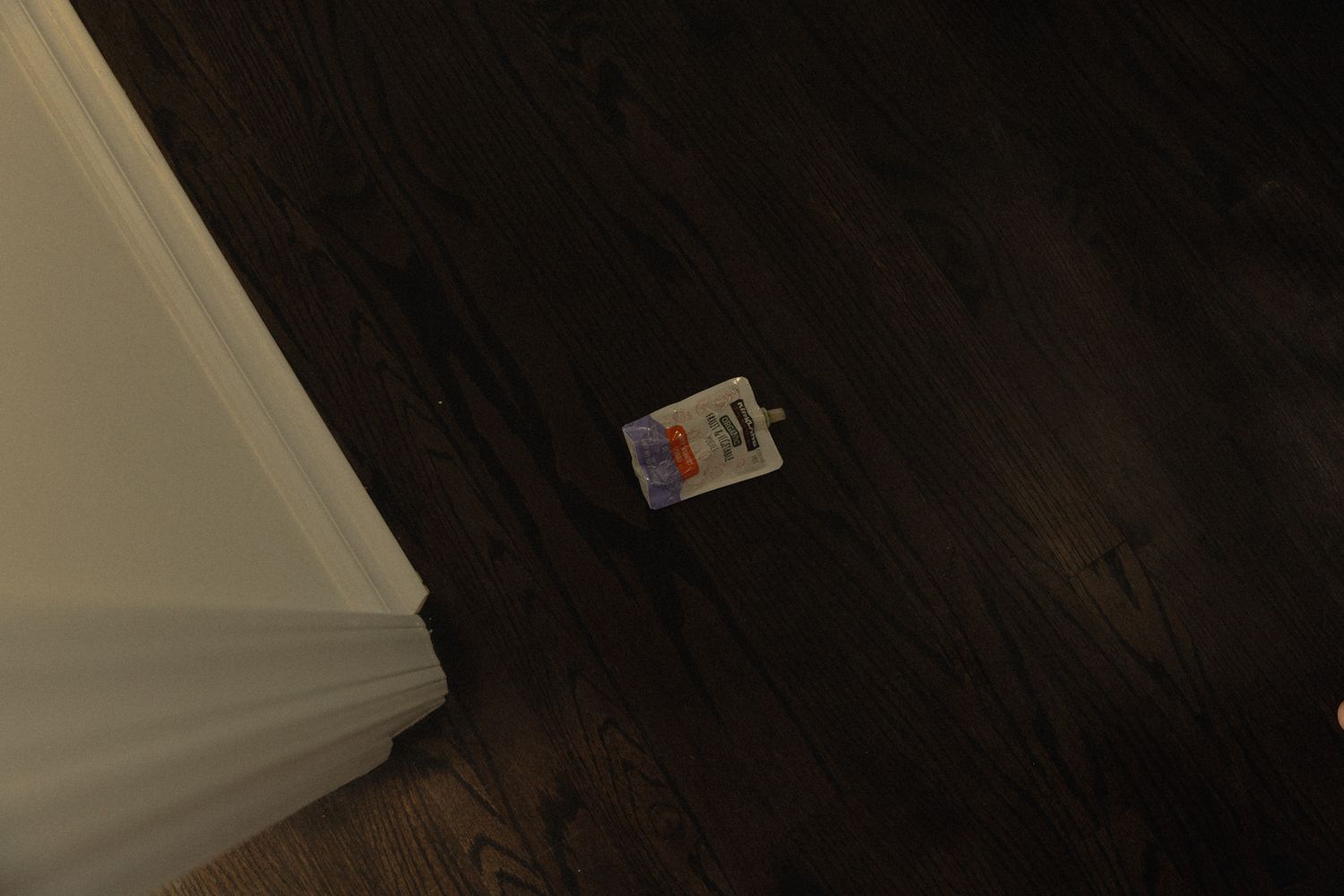 Dark hallway with hardwood flooring and white trim baseboards.