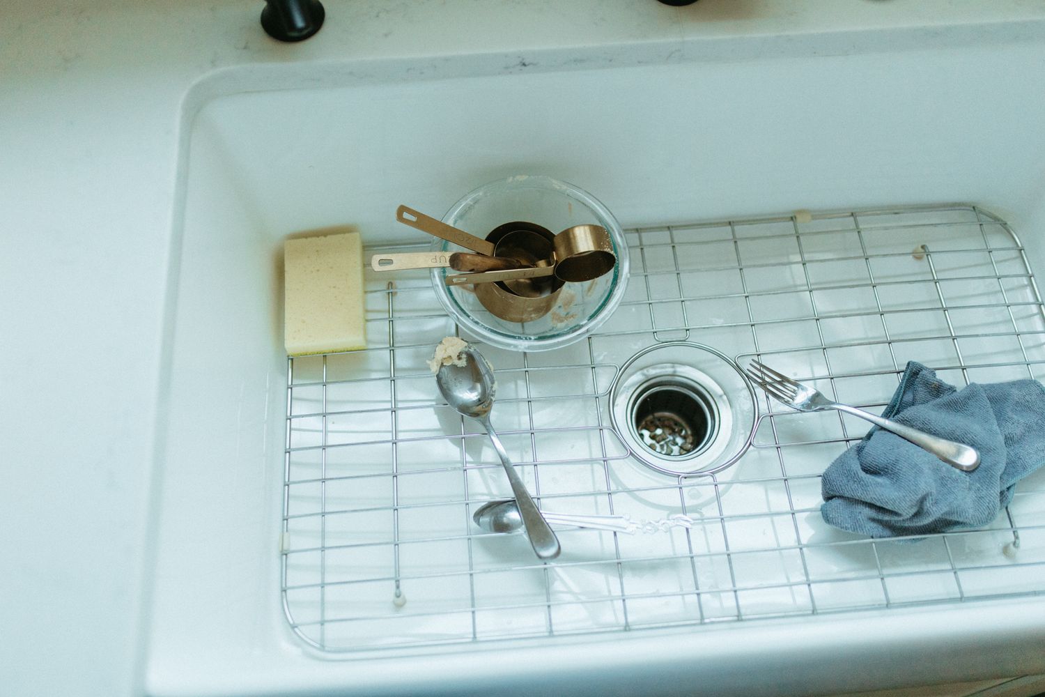 Overhead view of bathroom fixtures and metal accessories on a white counter.