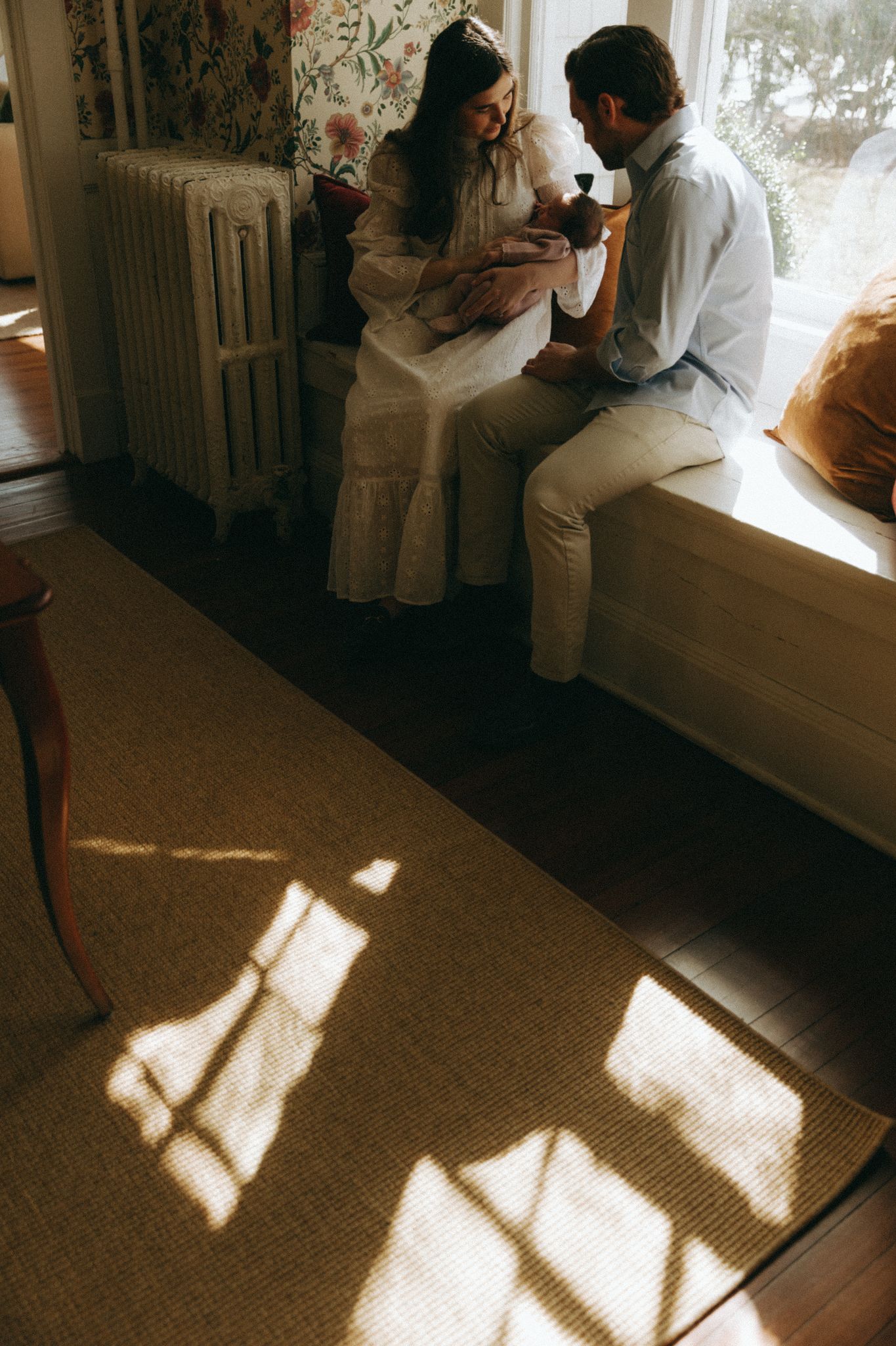 Sunlight streaming through windows creating dramatic shadows on carpeted floor.