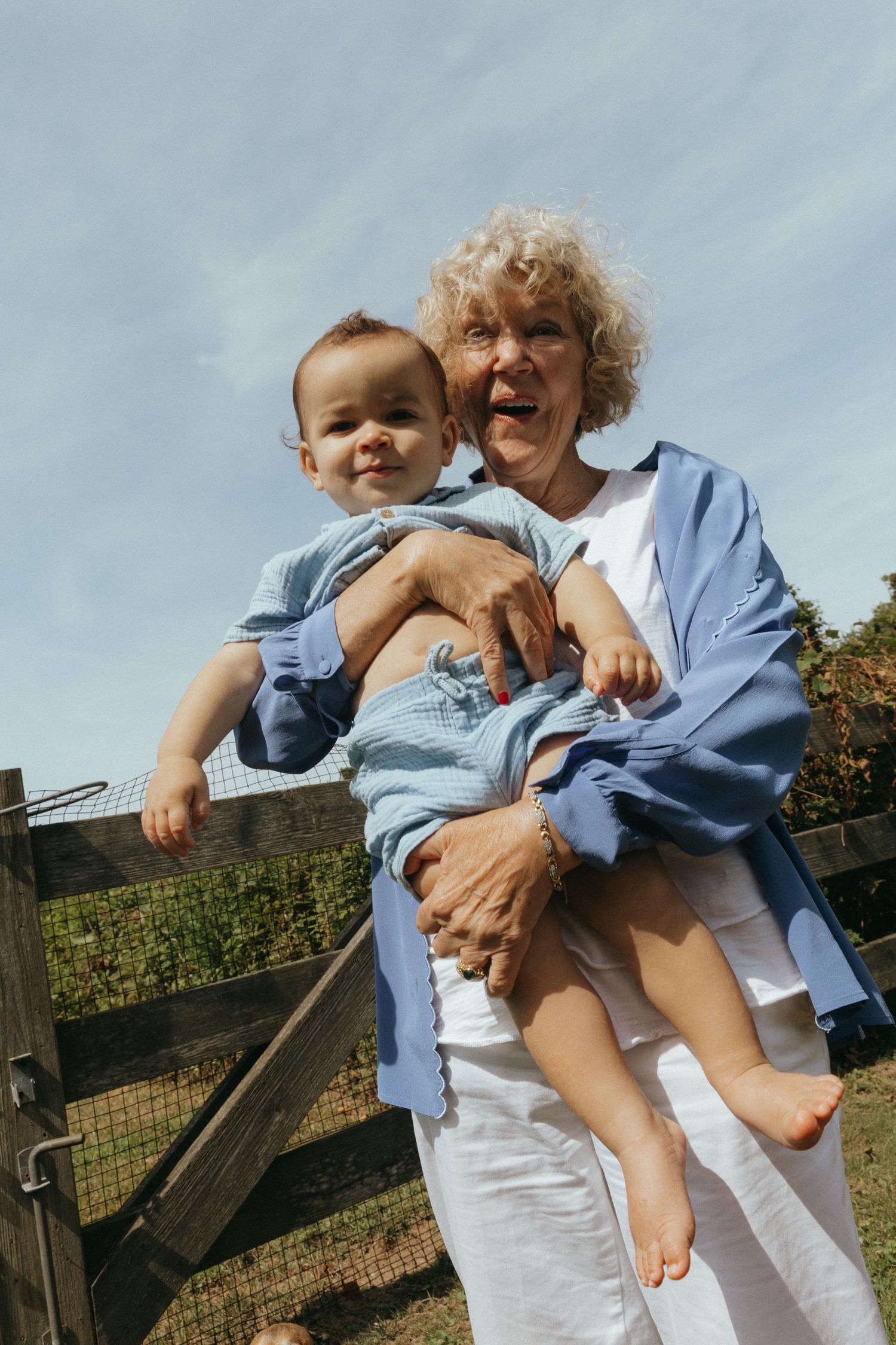 Playful outdoor moments captured against rustic fence backdrop.