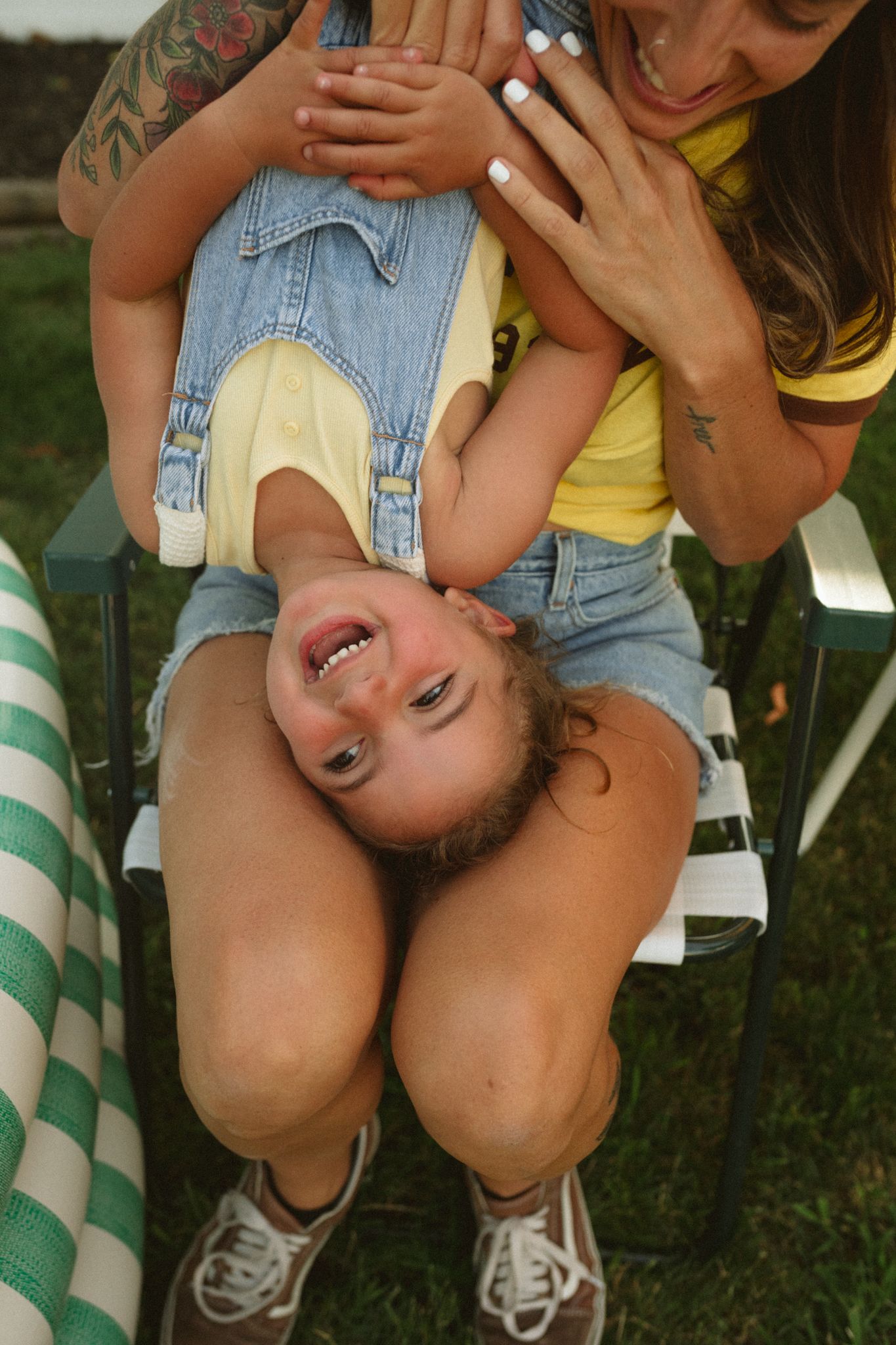 Playful summer moment captured with denim overalls and joyful expressions.