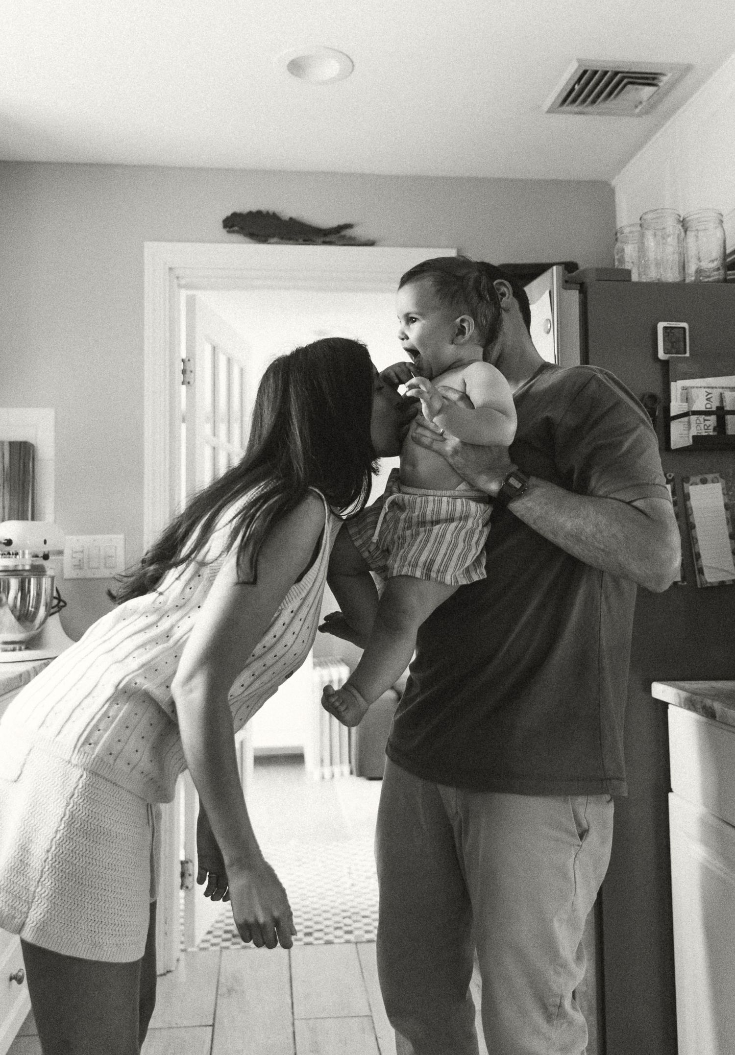 Black and white sequence of playful interactions in a home hallway.