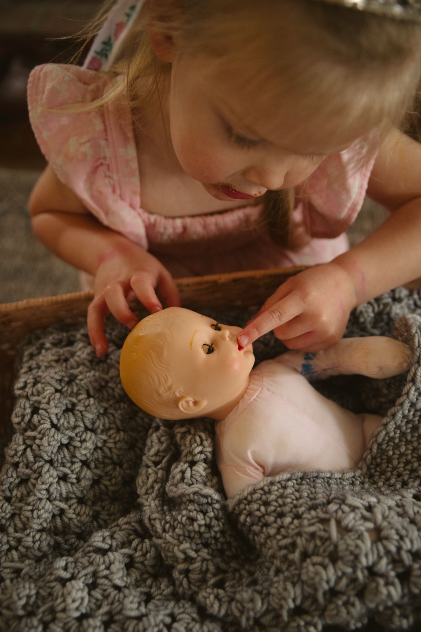 A baby doll being examined on a patterned blanket.