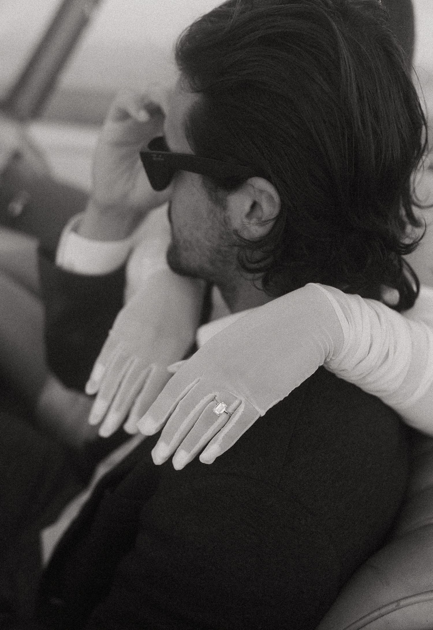 Black and white close-up of gentle hand placement on shoulder.