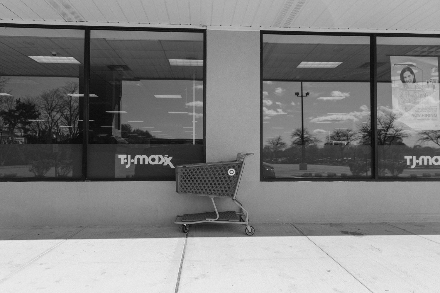 Empty retail storefront with TJ Maxx signage visible in black and white.
