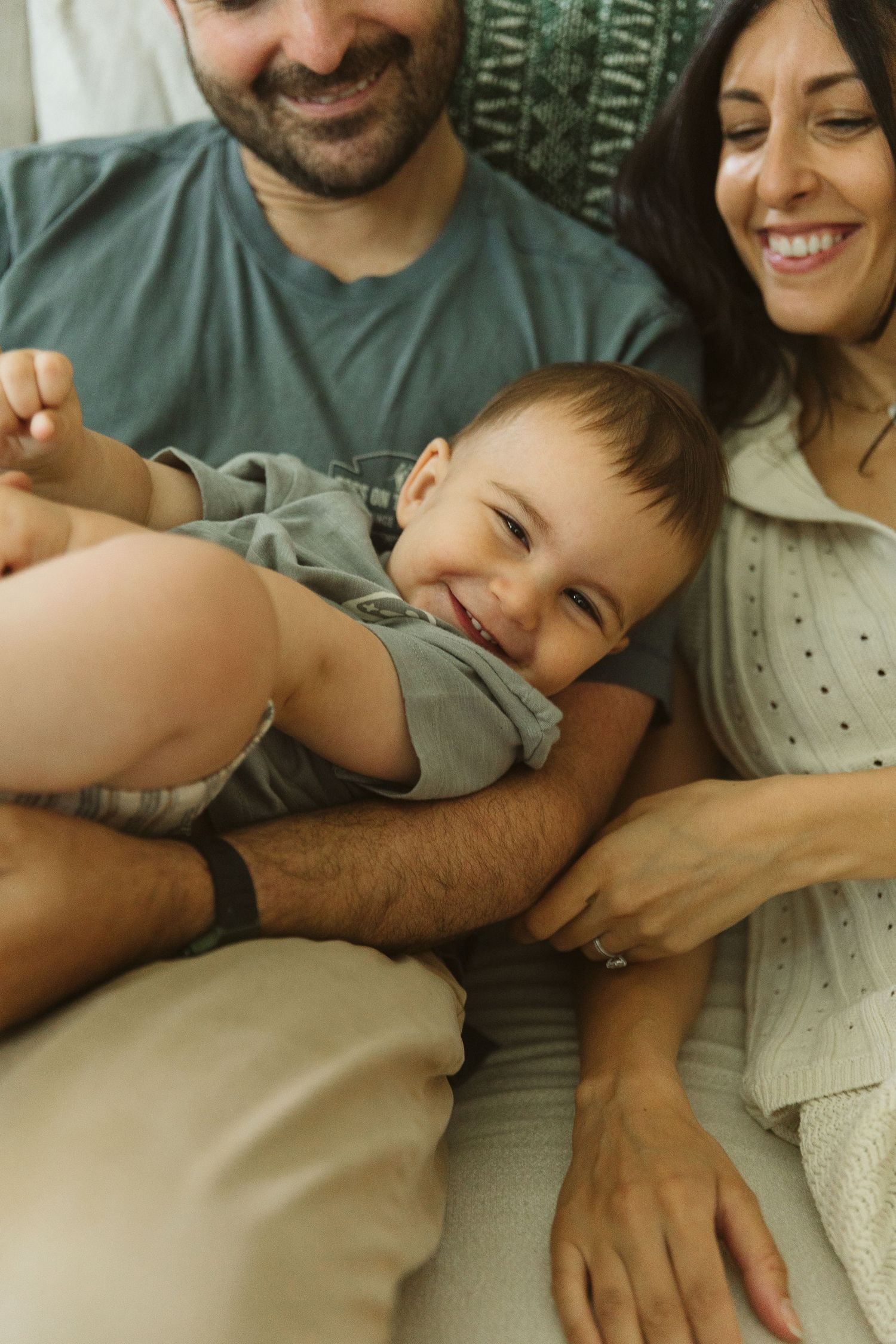 Candid family moment captured on a couch showing affectionate interaction.