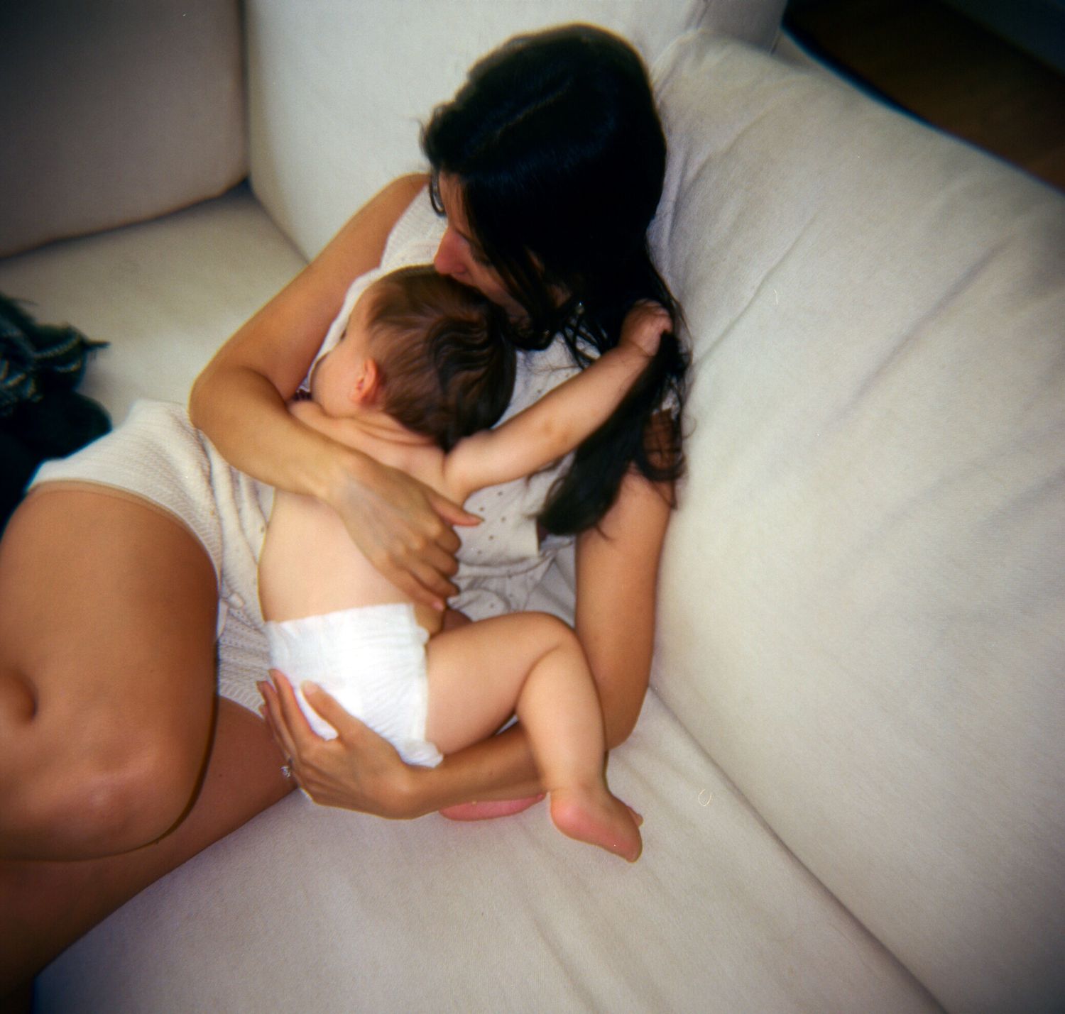 Intimate monochromatic series showing tender moments on a white couch.