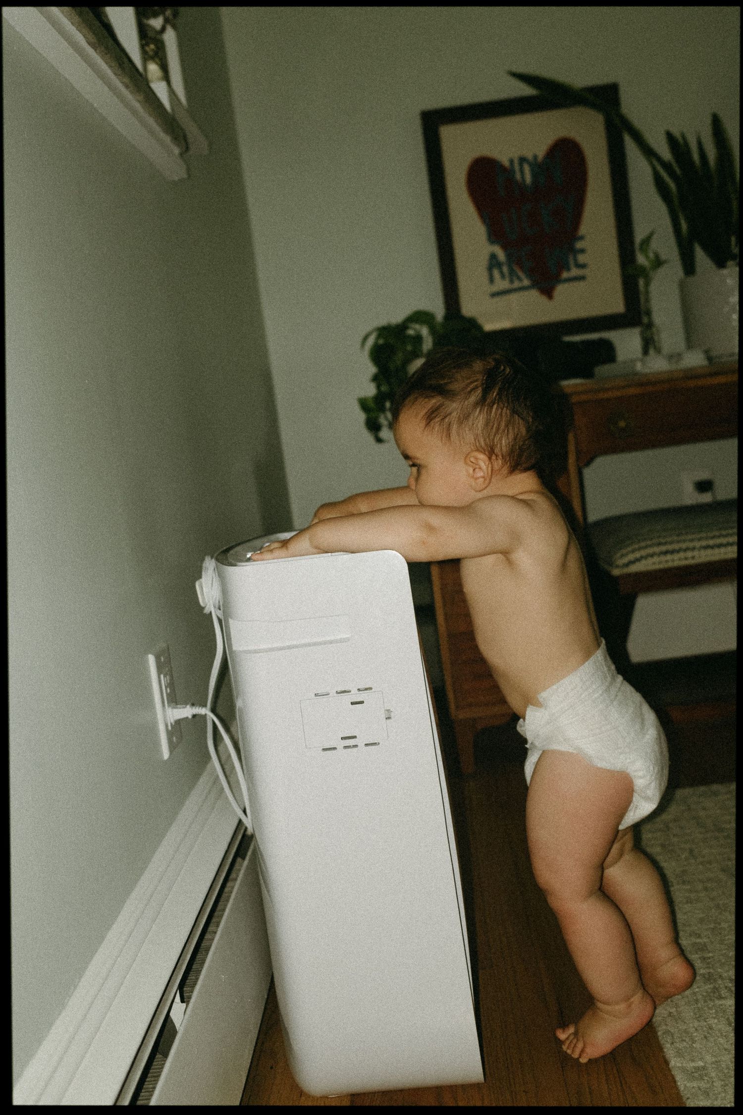Sequence showing a toddler exploring near a white appliance in a home setting.