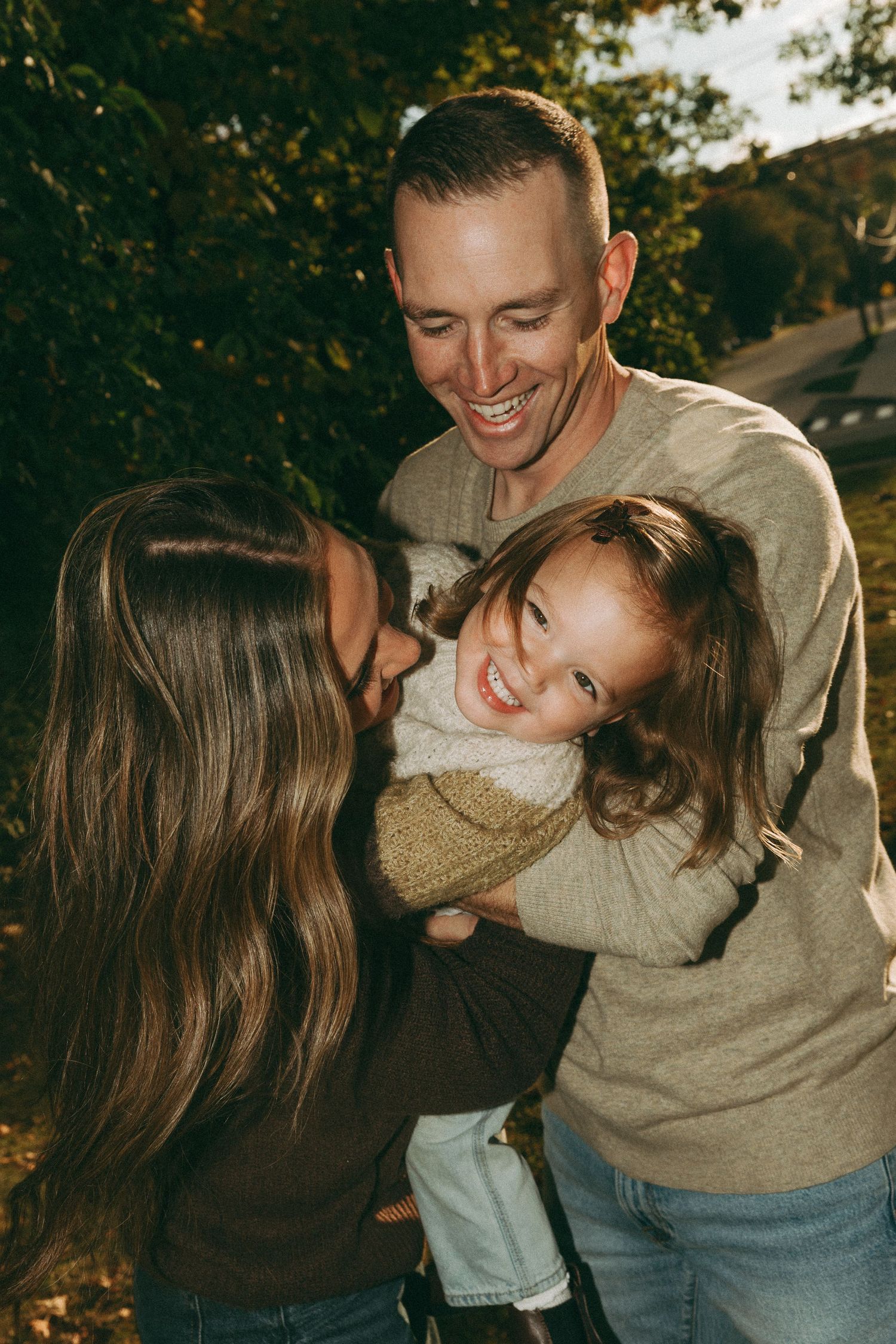 Couple sharing playful and intimate moments outdoors in autumn setting.