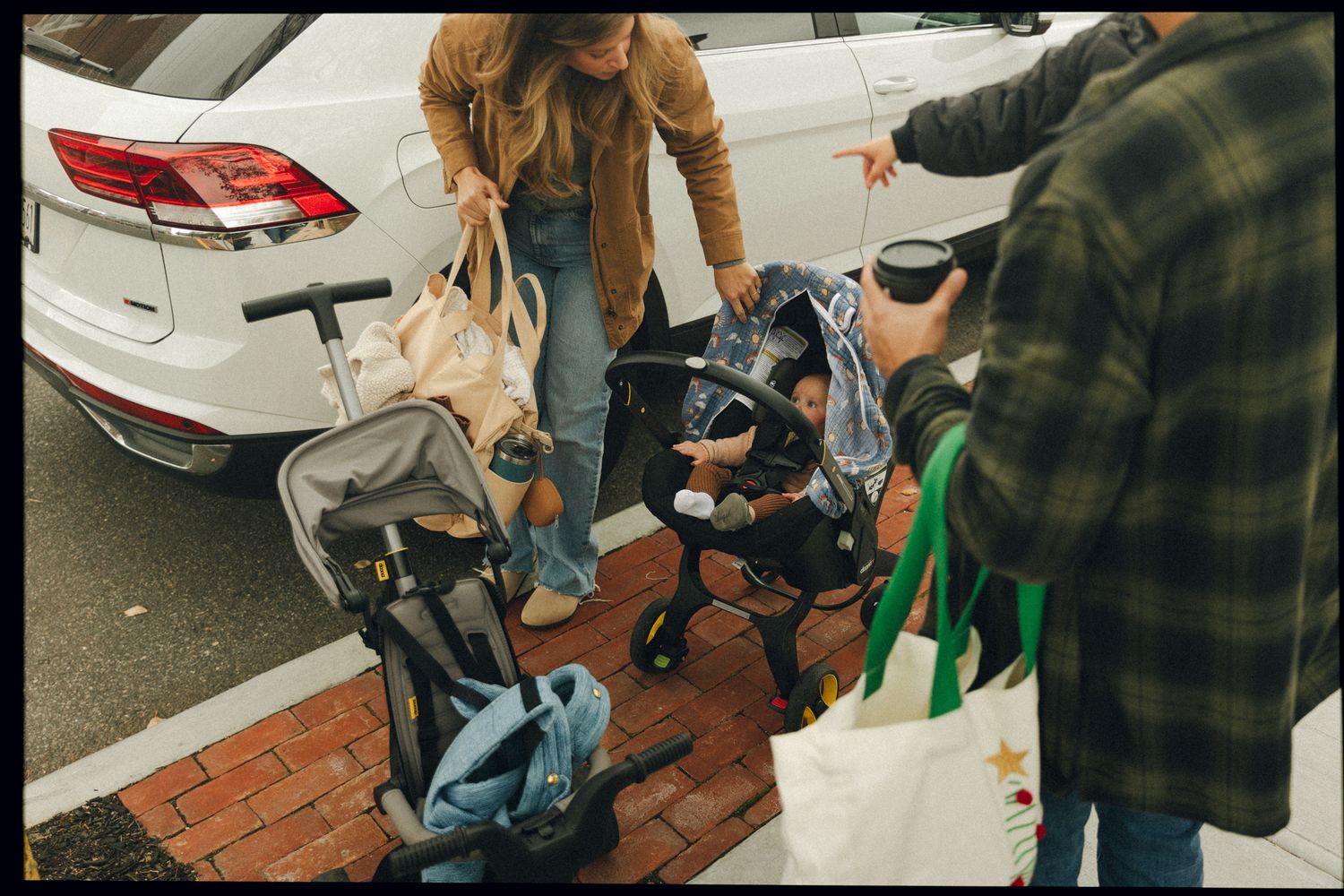 Group gathering around parked cars with casual outdoor atmosphere.