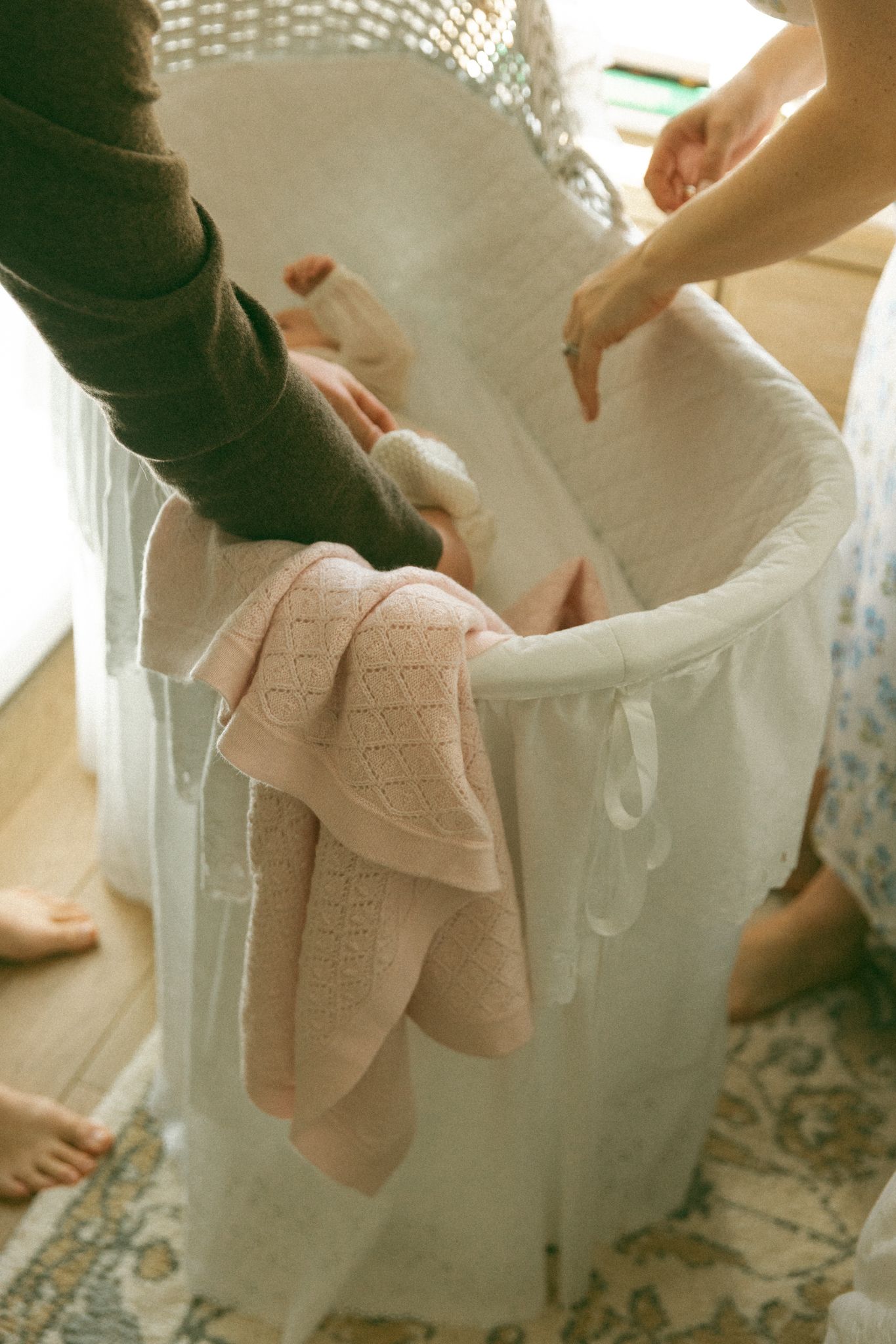 Hands placing soft white towels into a large porcelain bathtub.