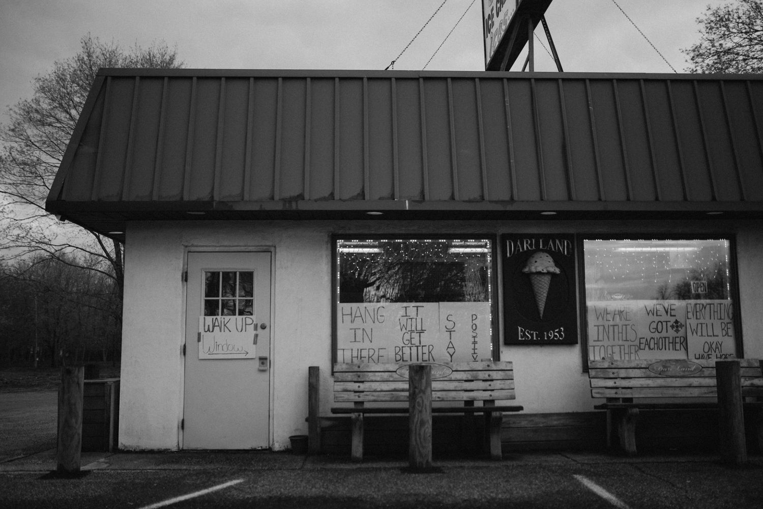 Row of abandoned rural buildings and storefronts captured in monochromatic tones.