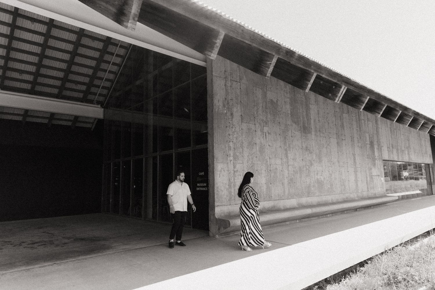 Long concrete corridor with angular walls and dramatic lighting.