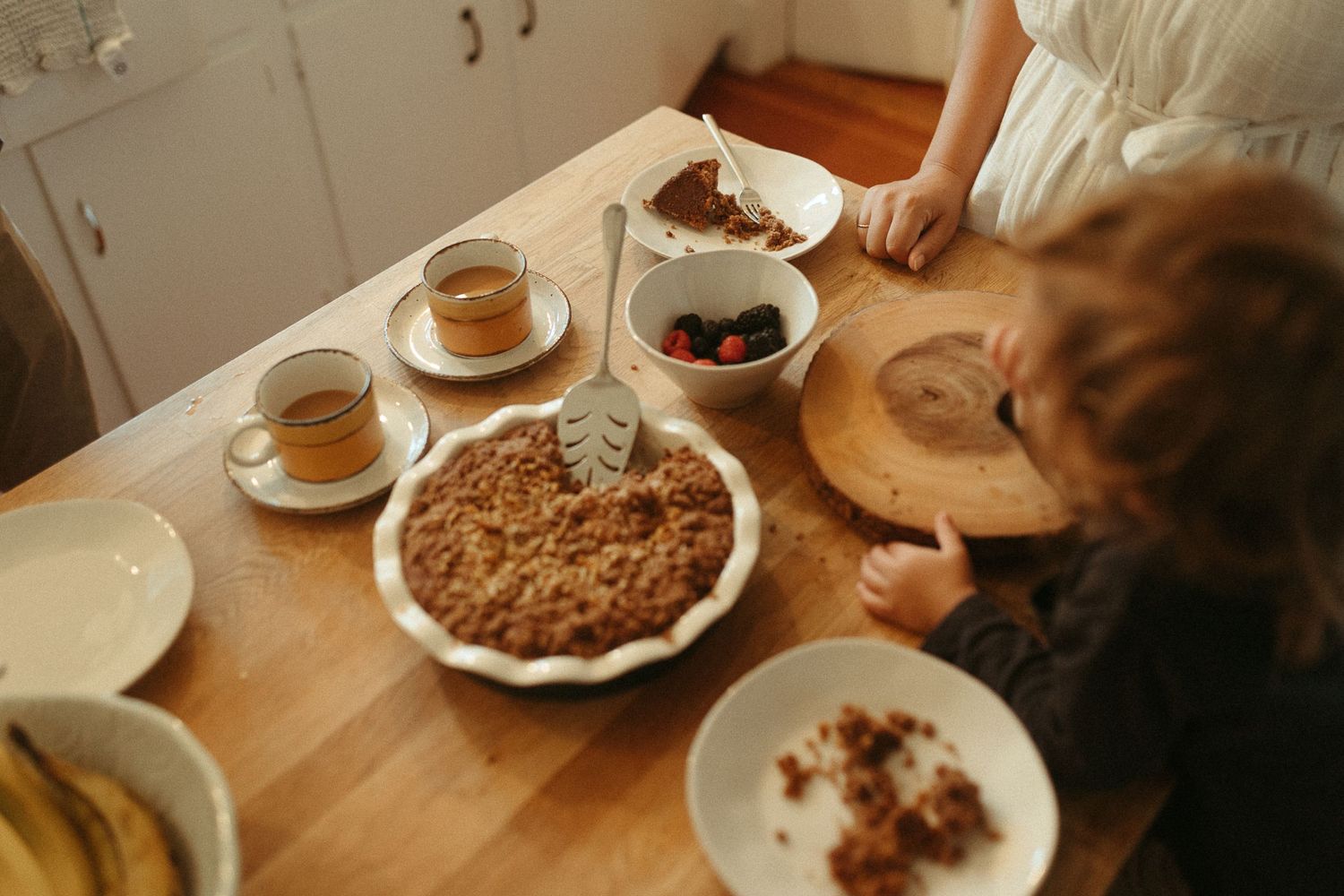 Cozy indoor scene with plates of food and drinks on a wooden table.