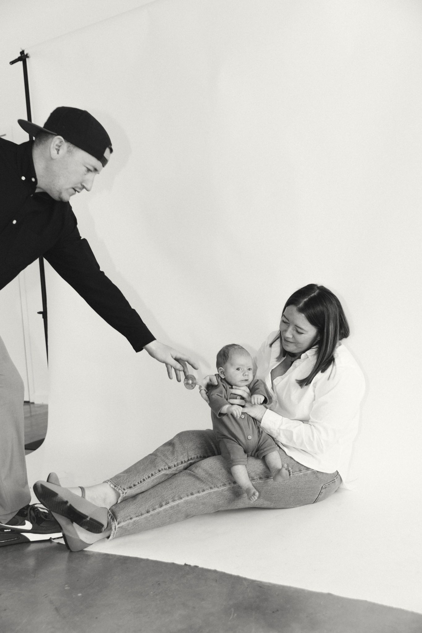 Family photo sequence showing playful moments along a white studio wall.
