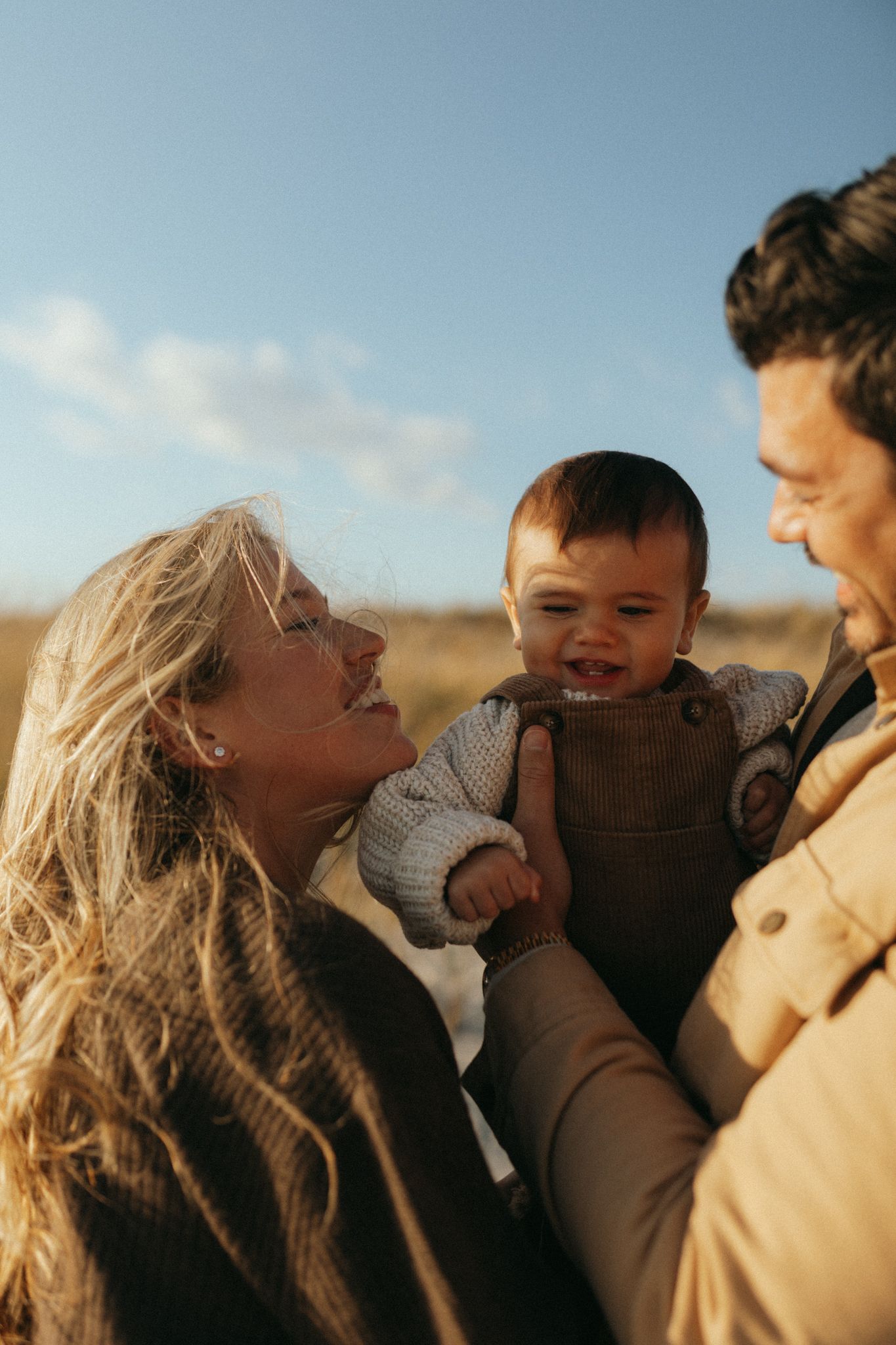A joyful family moment captured at golden hour on a beach.