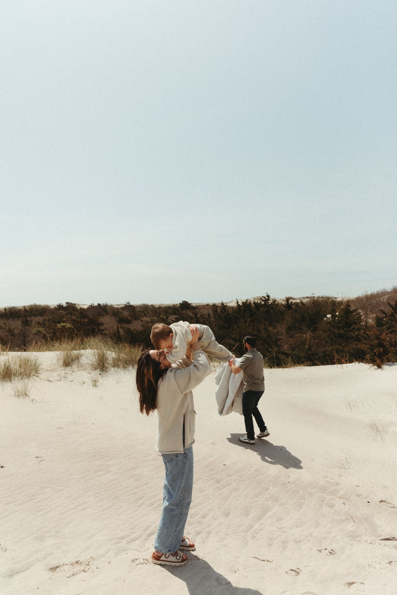 A panoramic sequence of people playing and interacting on white sand dunes under a bright sky.