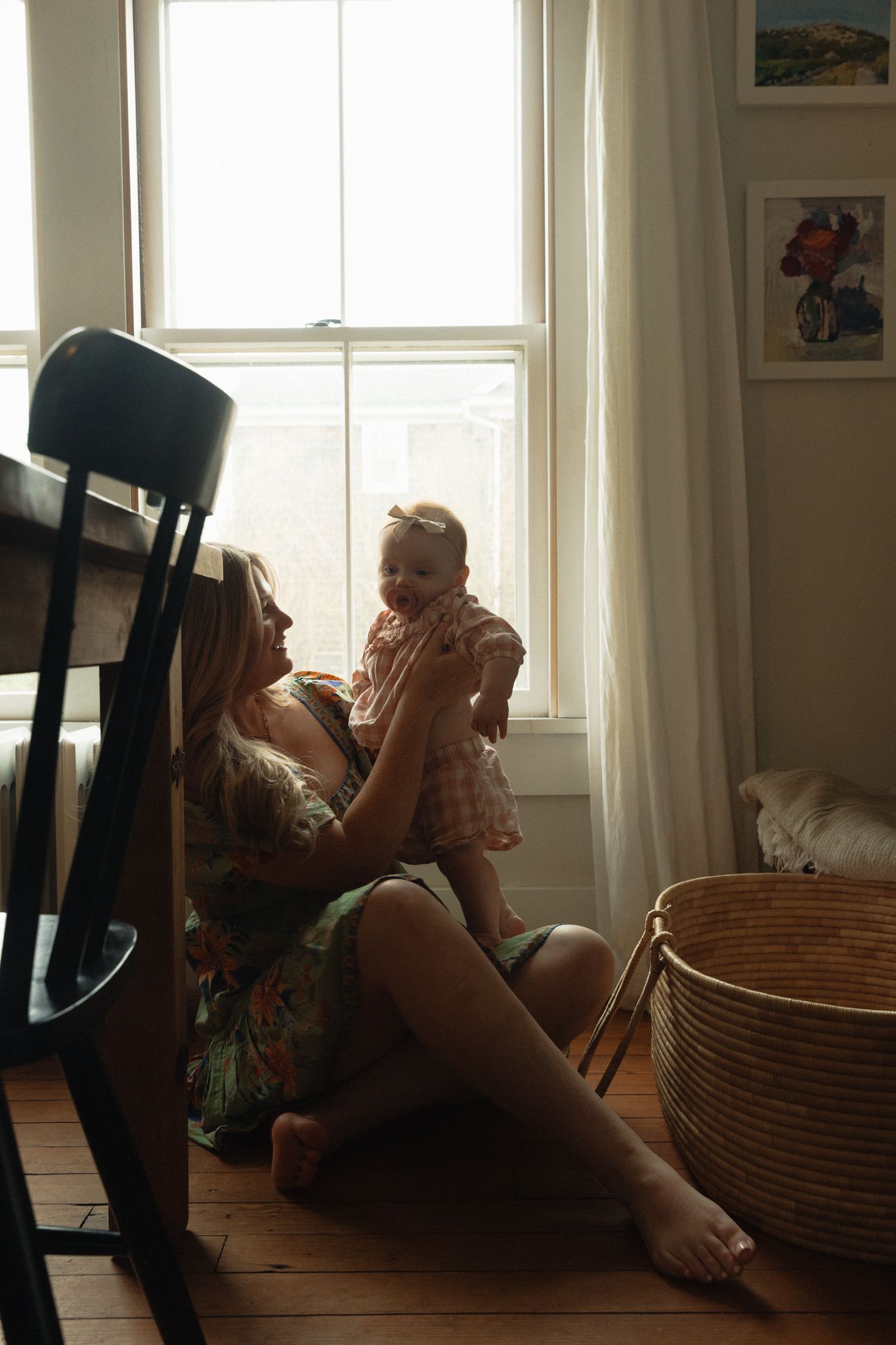 Silhouettes against bright windows with a woven basket in a sunlit room.