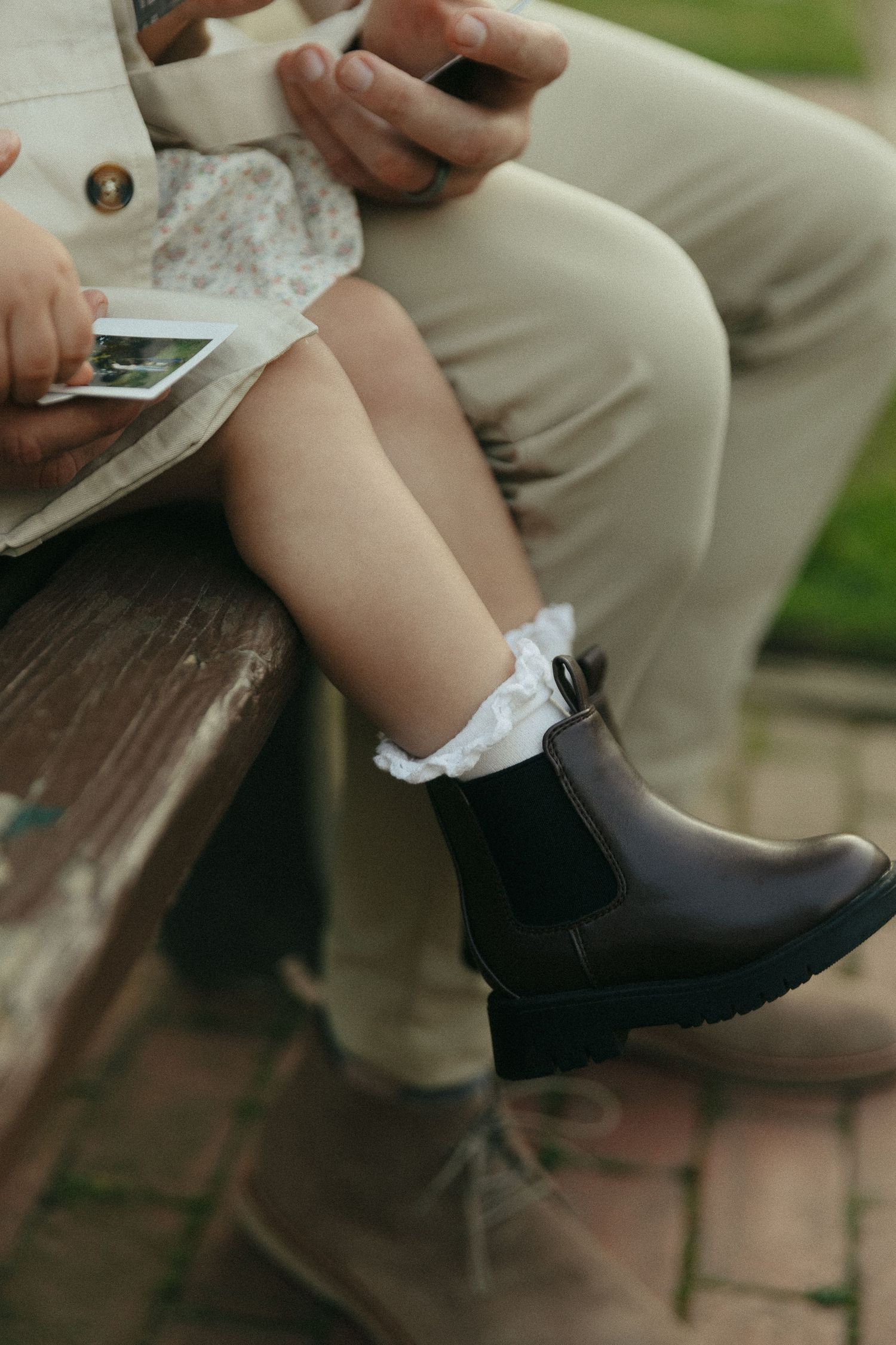 Close-up of black dress shoes and socks being put on outdoors.