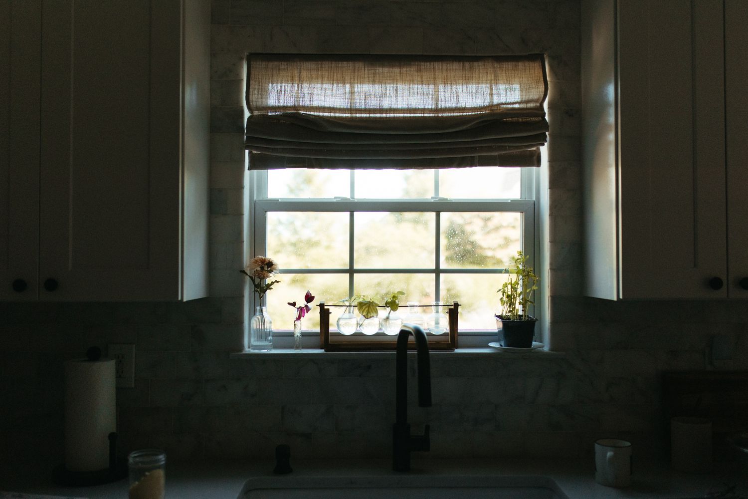 Dark interior room with light streaming through windows creating silhouette effect.