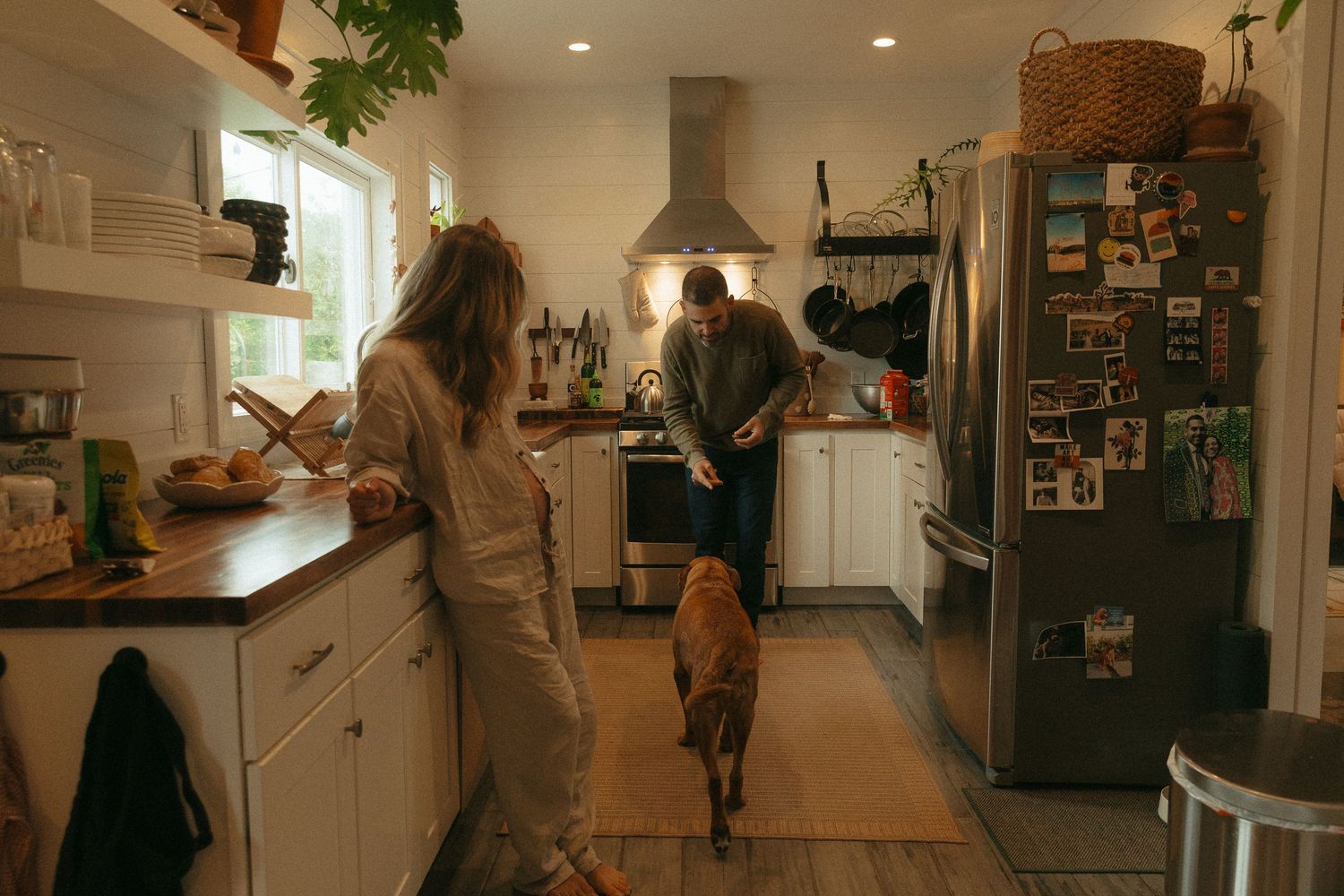 Interior panorama of a cozy home showing kitchen and living spaces with warm lighting.