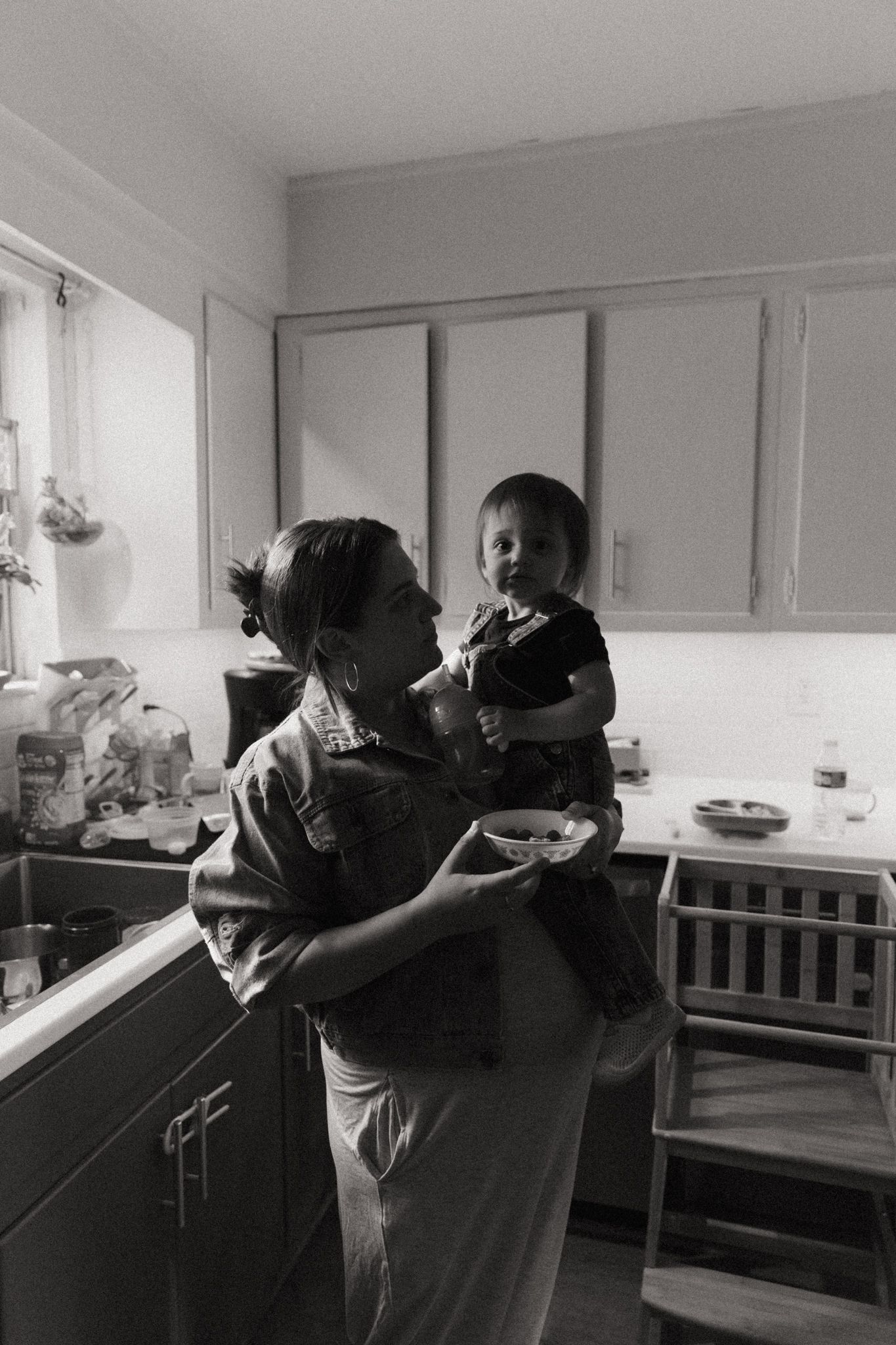 A tender moment captured in black and white in a vintage kitchen setting.