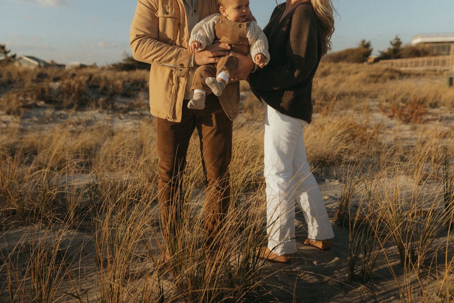 Group enjoying a playful moment together in a golden grass field at sunset.