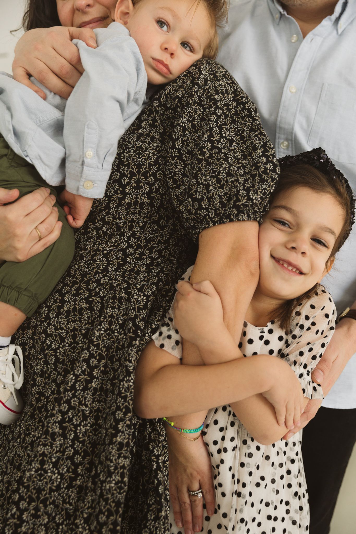 Family group poses showing affectionate moments in casual attire.