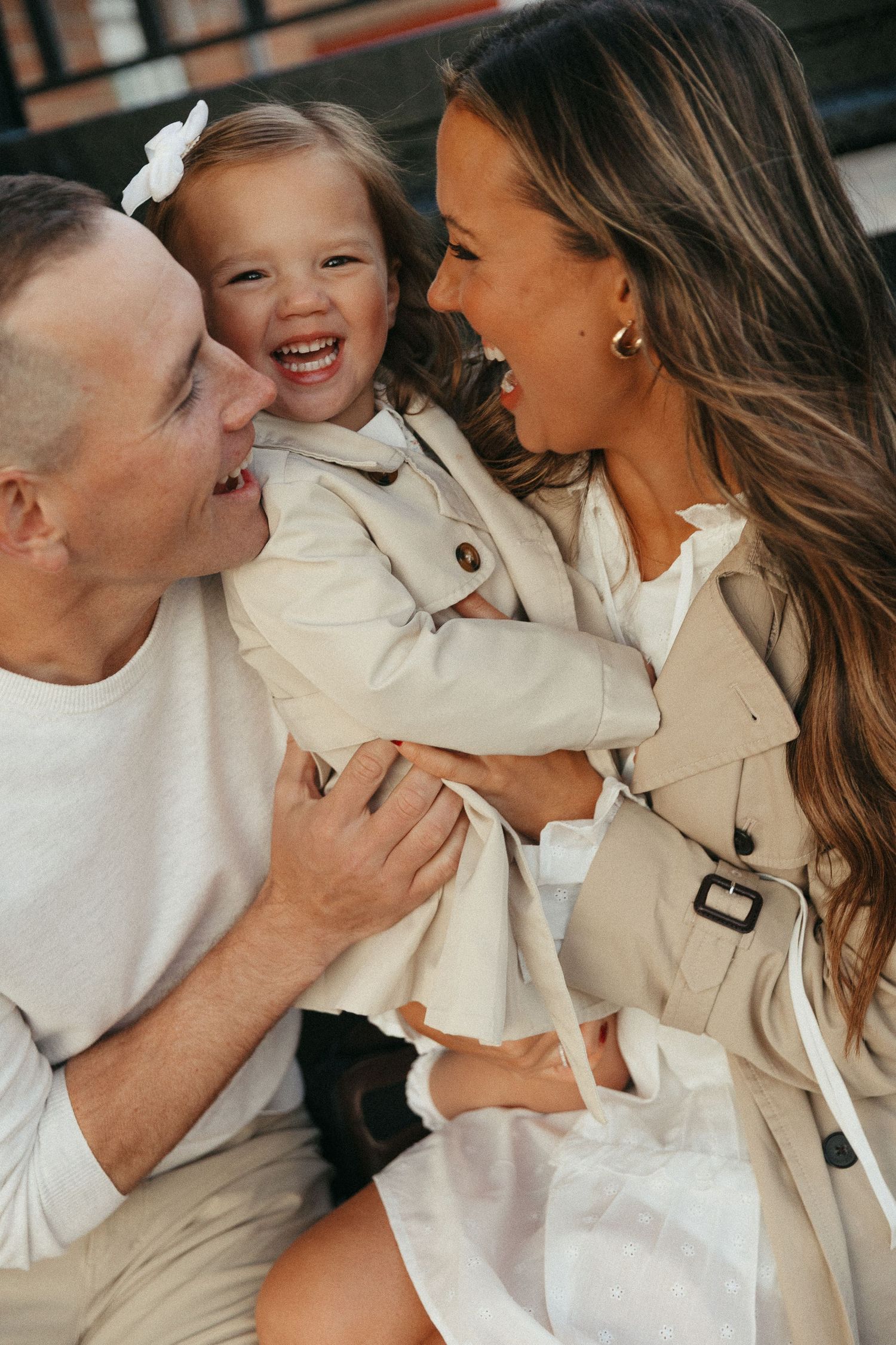Candid family portrait showing joyful expressions and embraces in neutral tones.