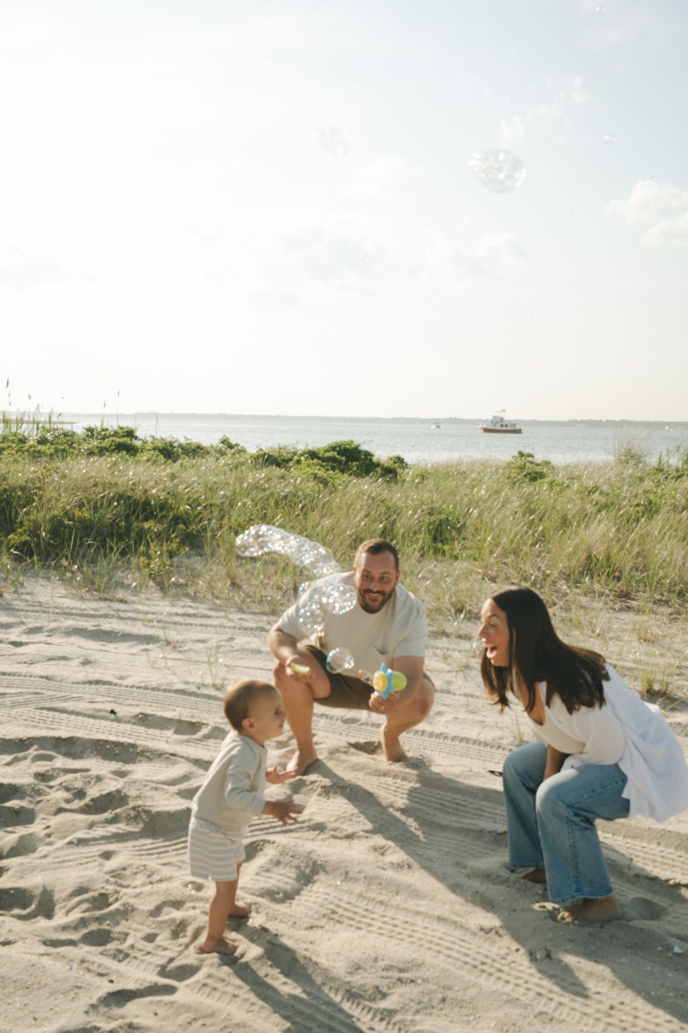 Family having fun splashing water on sandy beach during sunset.