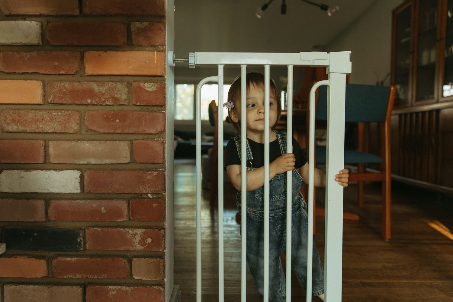 Red brick wall with white railing detail in warm indoor lighting.