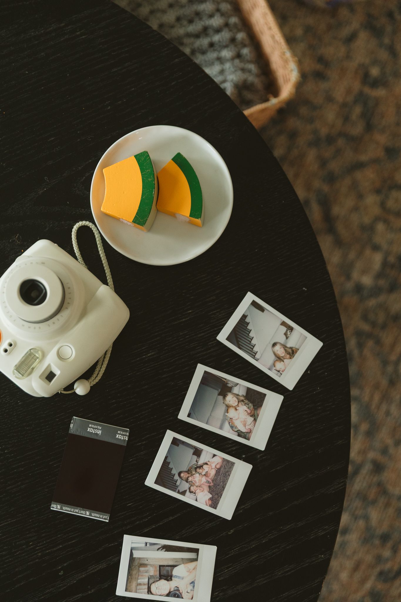 Polaroid photos and camera equipment arranged on a dark table surface.