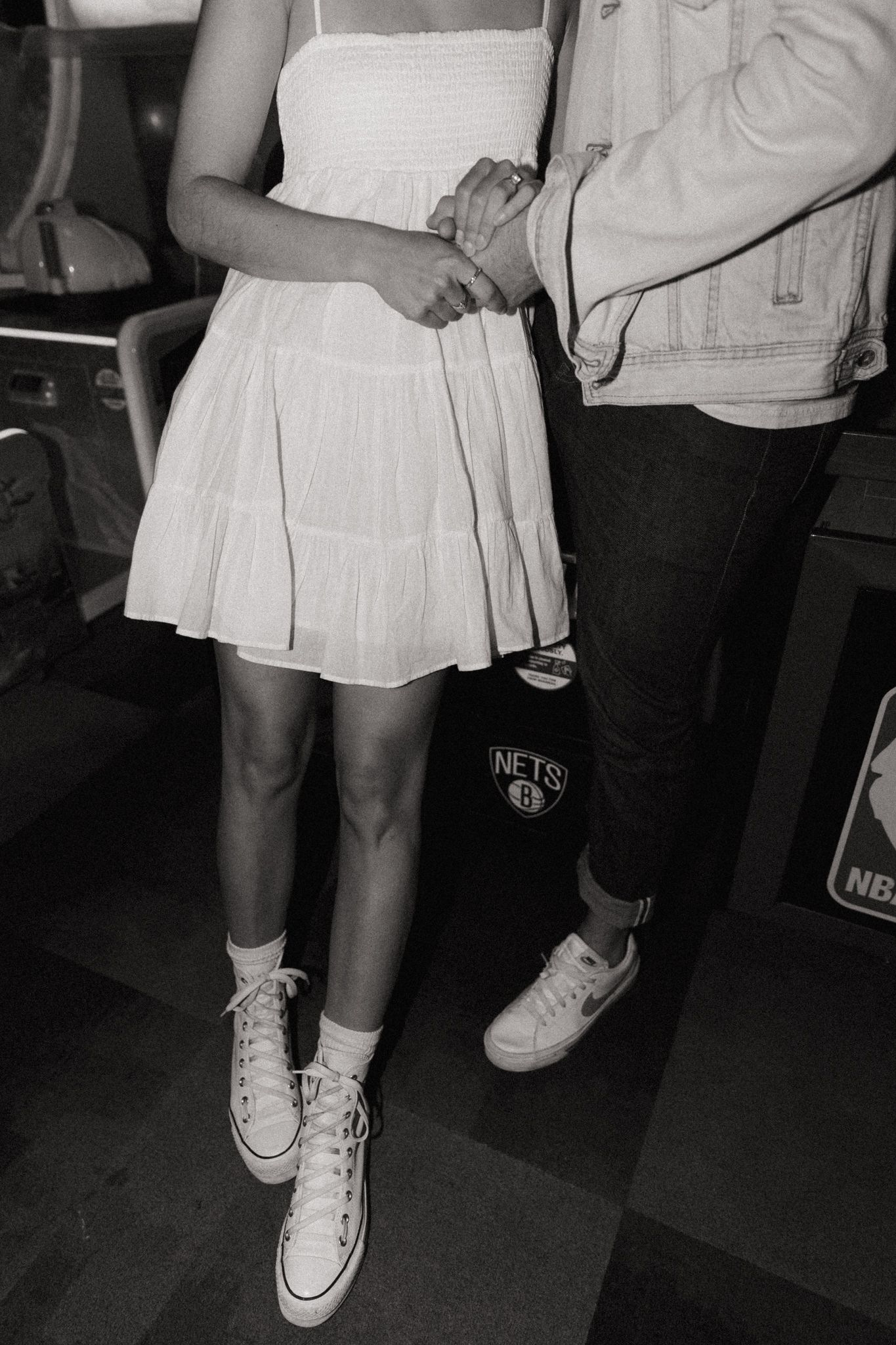 Black and white photos focusing on white sneakers and a pleated dress.
