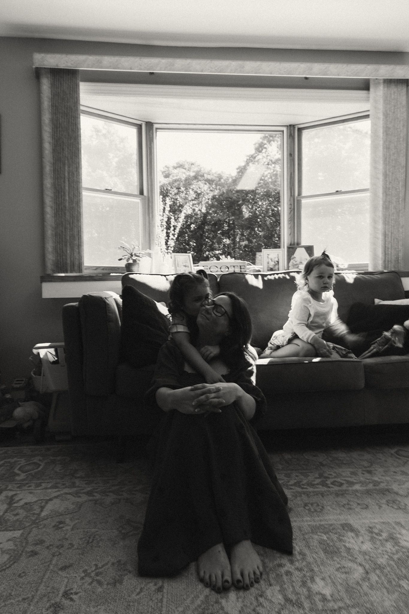 People lounging on comfortable sofas in a bright, window-lit room.