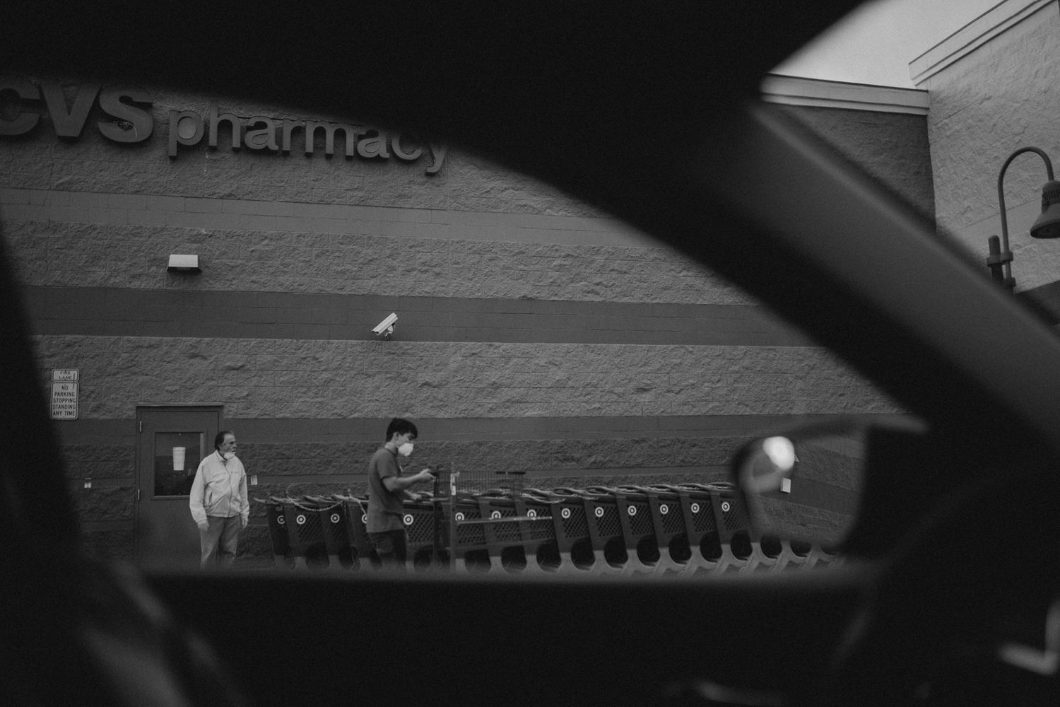 A black and white view of a CVS Pharmacy storefront with shopping carts.